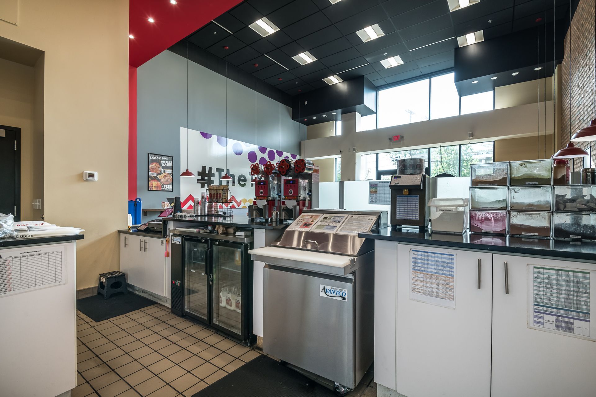 A kitchen in a restaurant with a lot of cabinets and appliances.