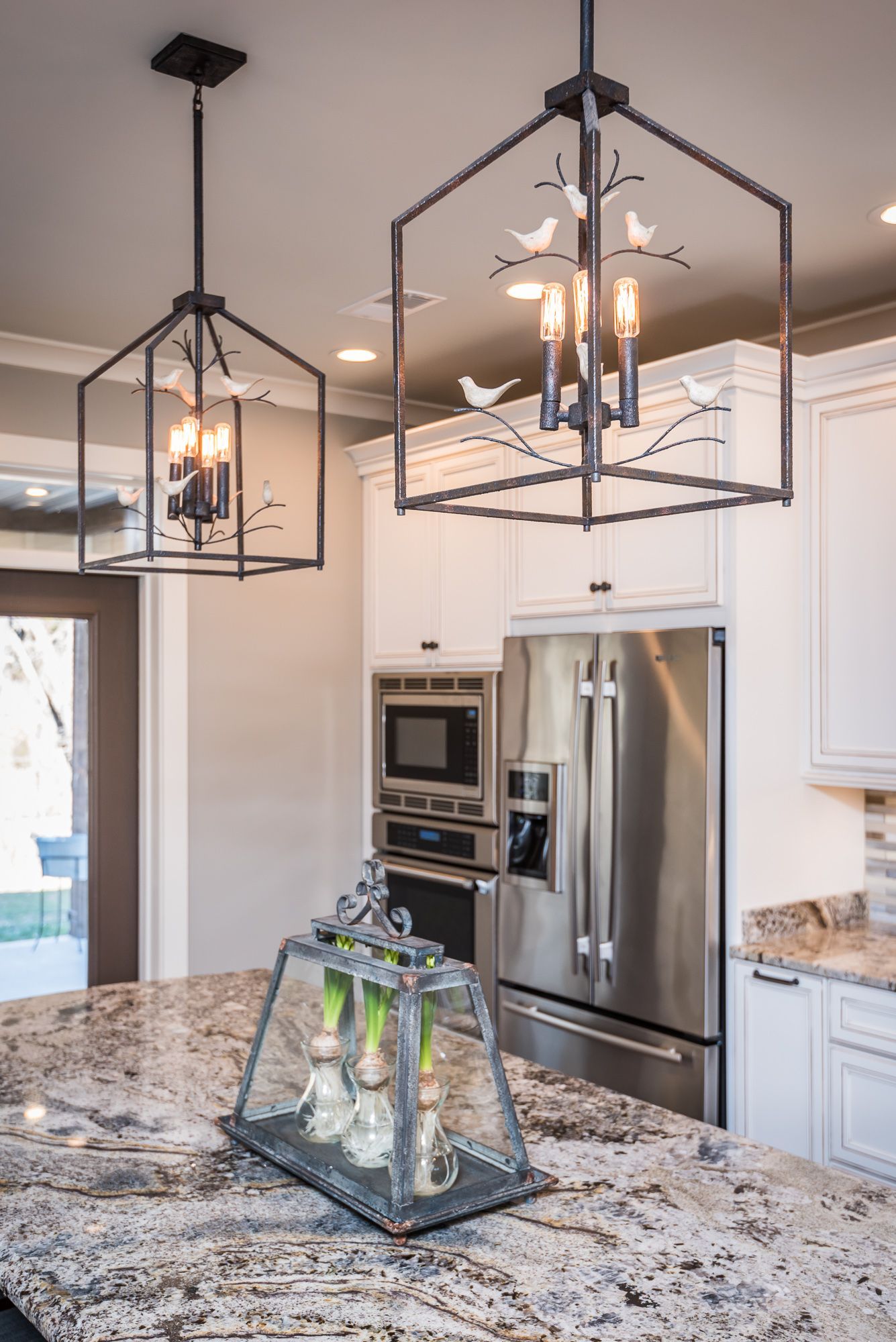 A kitchen with a stainless steel refrigerator and a granite counter top.