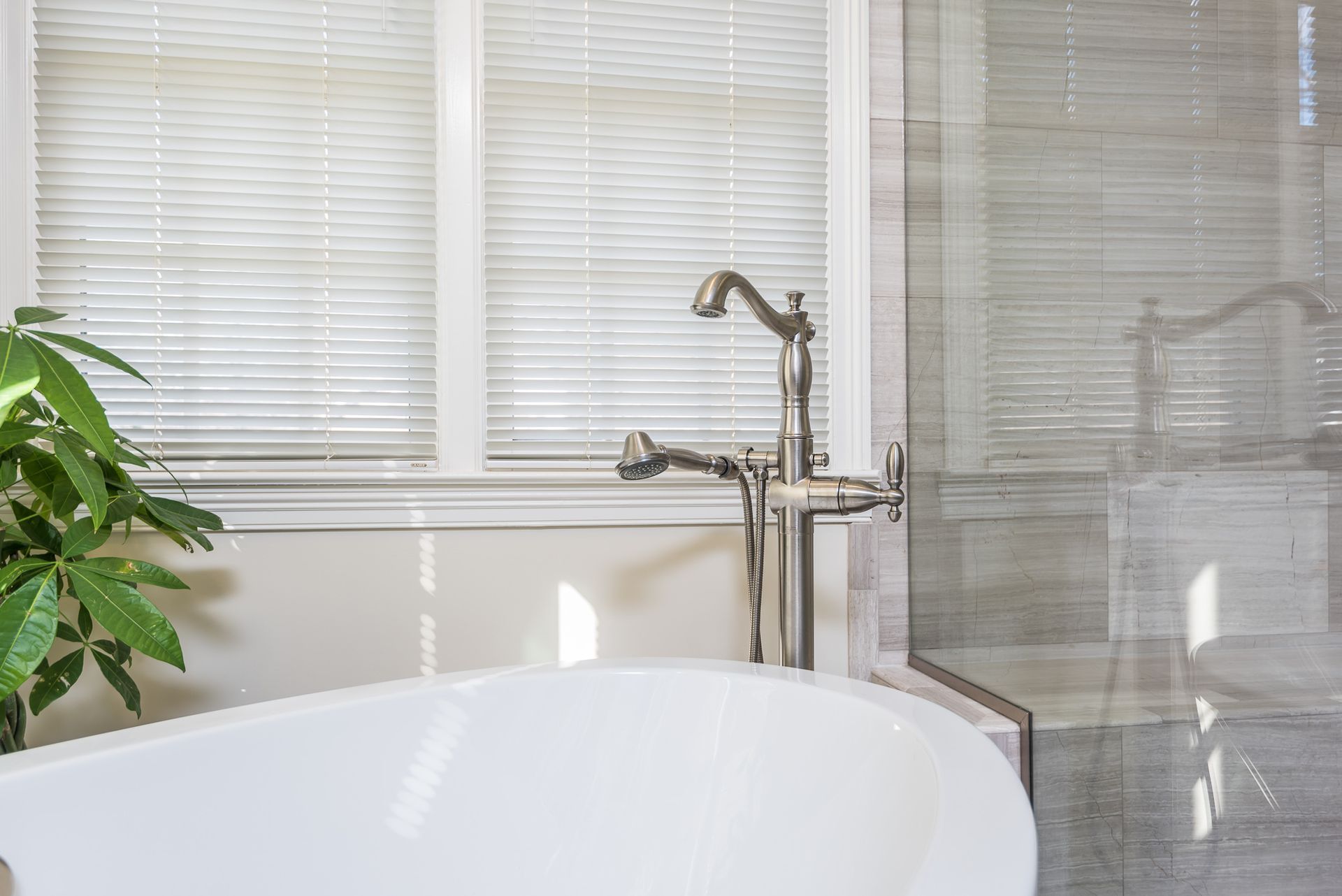 There is a bathtub in the bathroom next to a window.