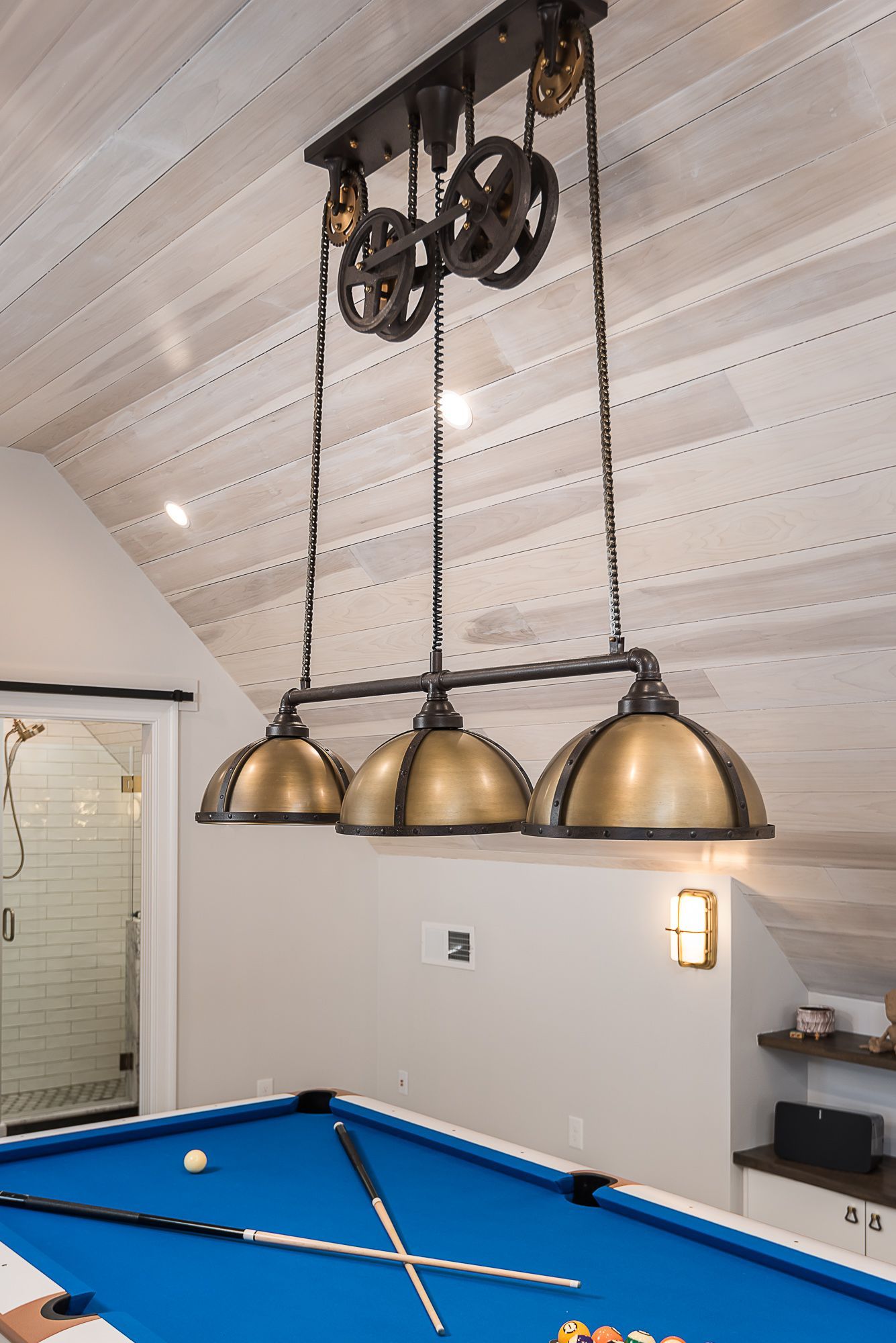 A pool table in a room with a light hanging from the ceiling.