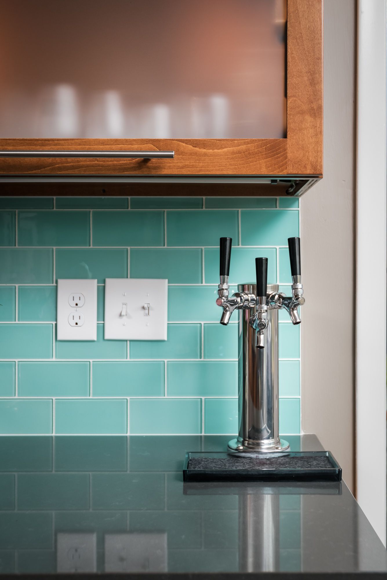 There is a beer tap on the counter in the kitchen.
