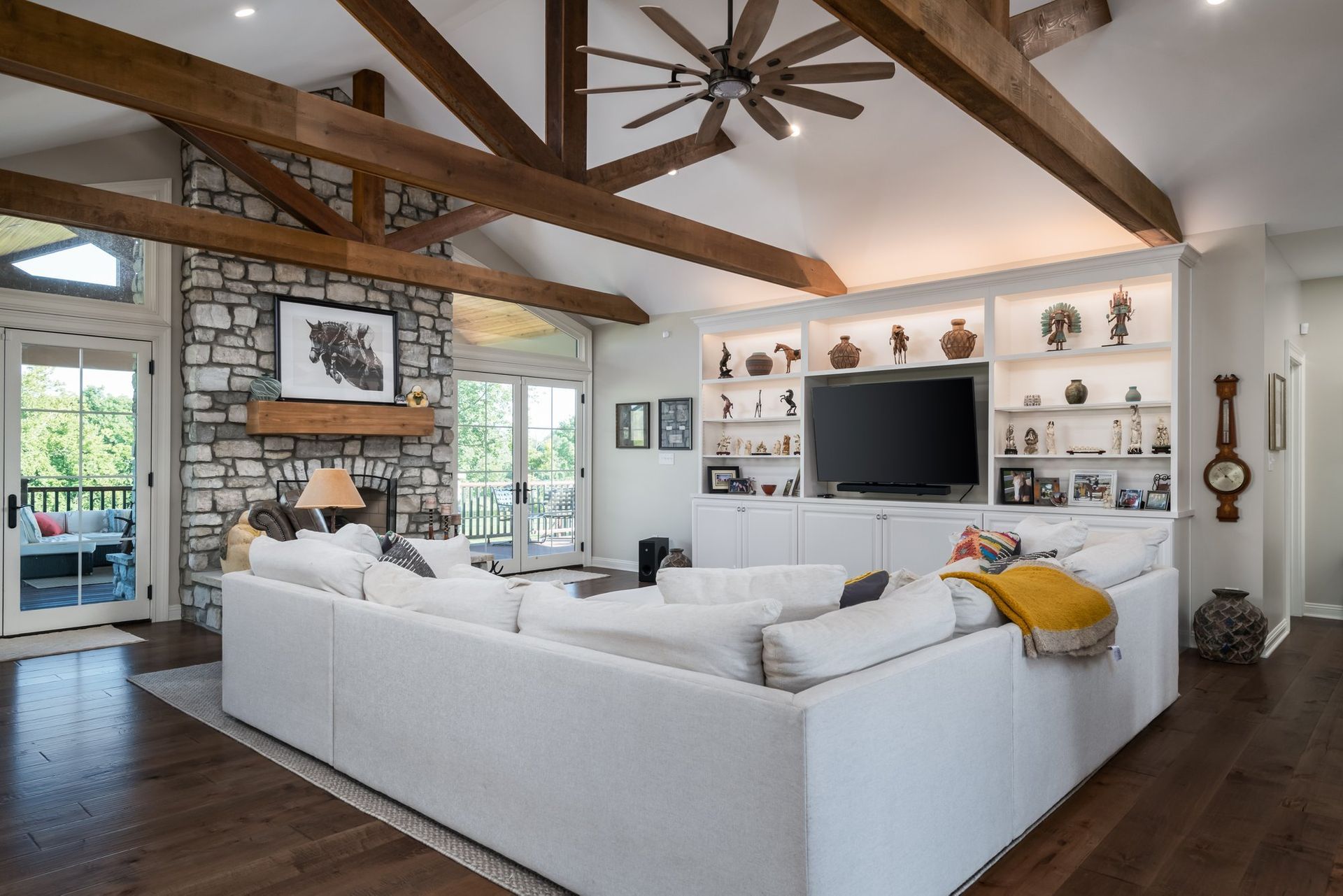 A living room with a large white sectional couch and a flat screen tv.