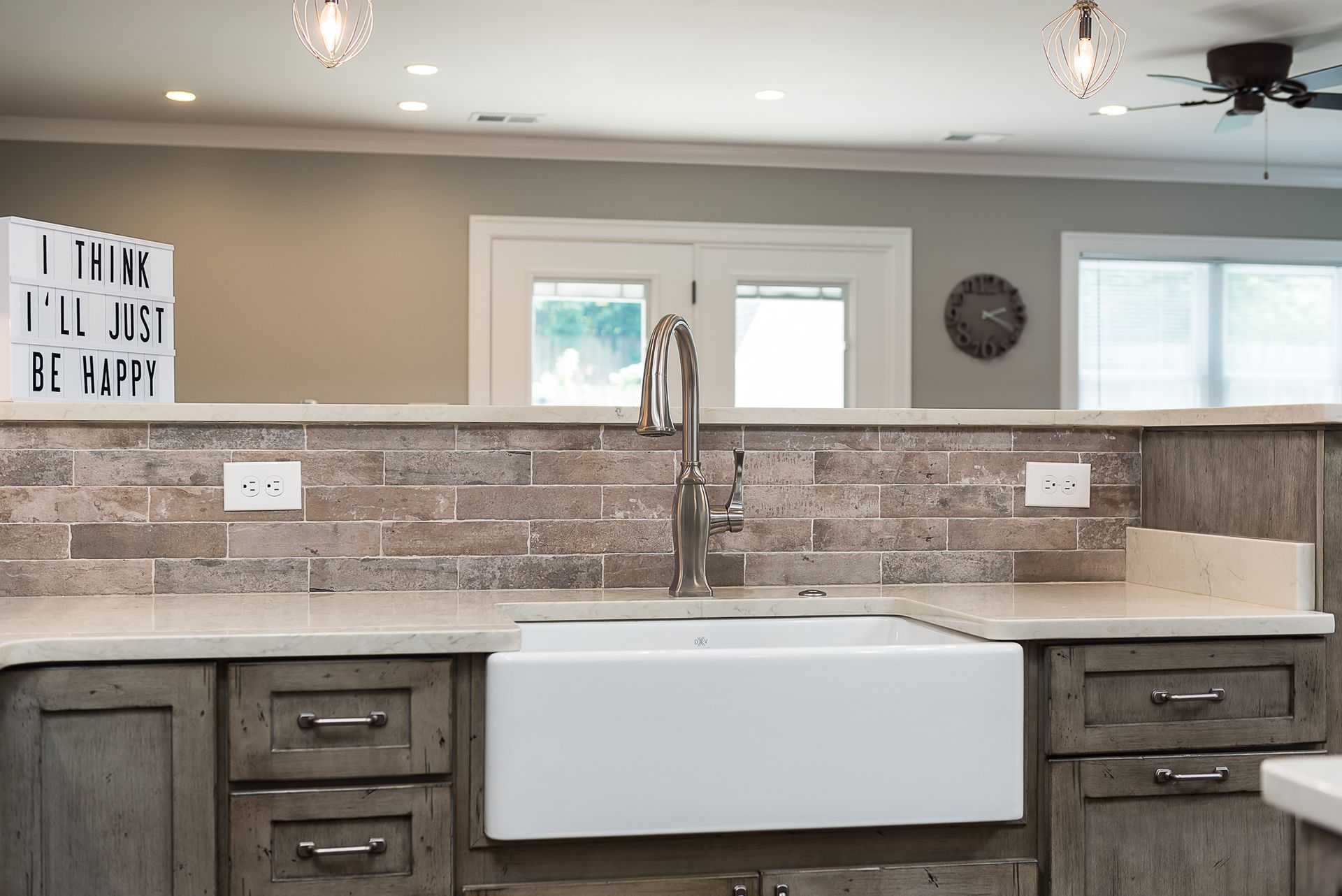 A kitchen with a white farmhouse sink and wooden cabinets.