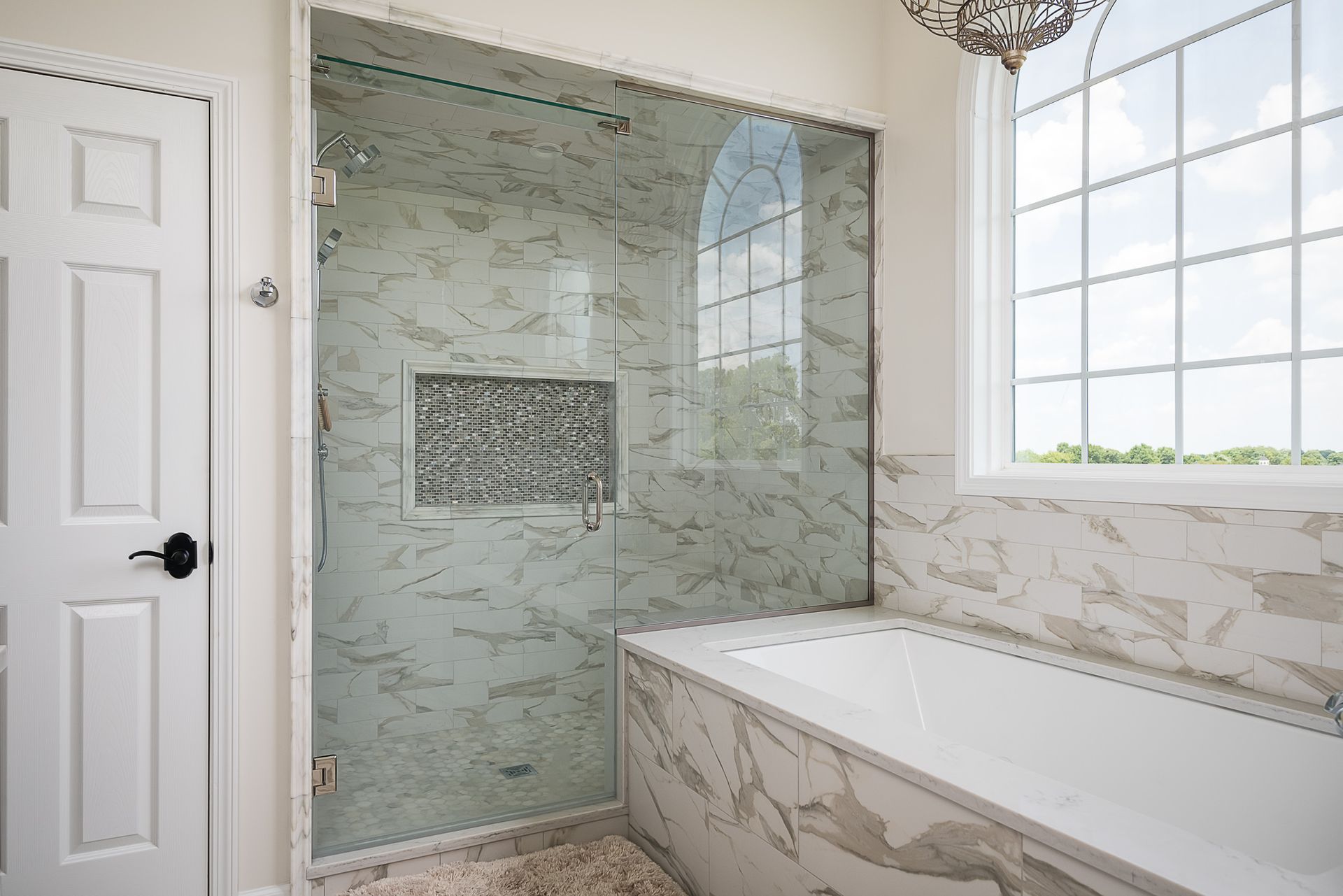 A bathroom with a walk in shower and a bathtub.