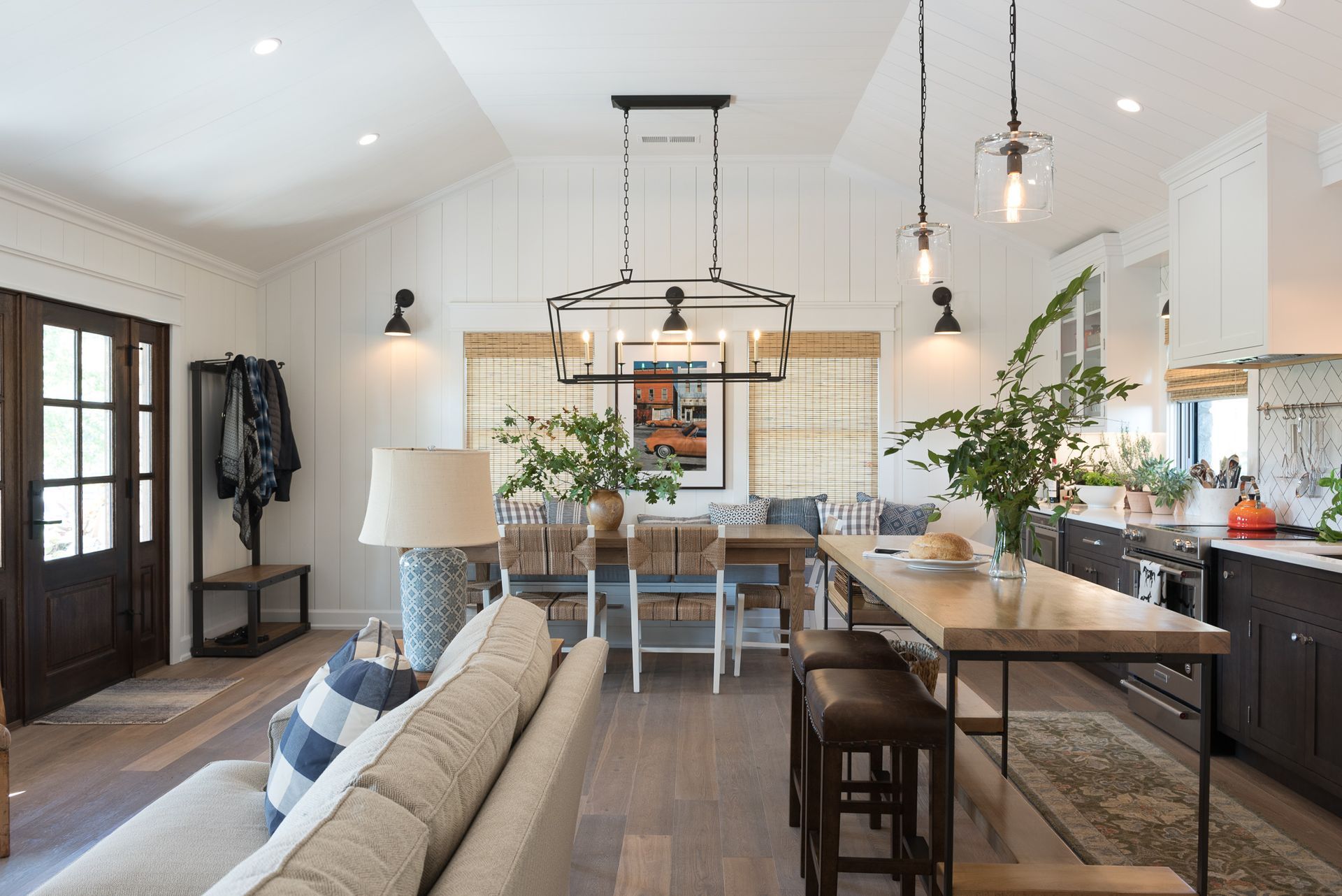 A living room with a couch , table and chairs and a kitchen.