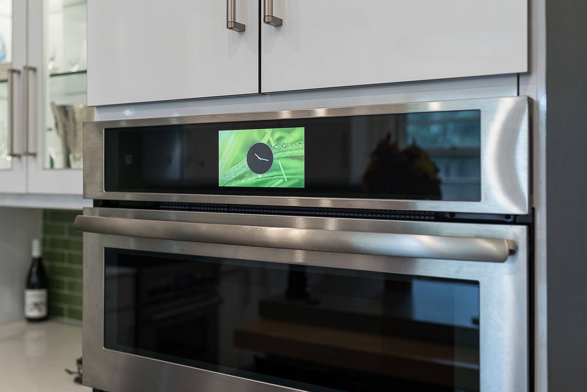 A stainless steel oven with a picture of a flower on the screen.