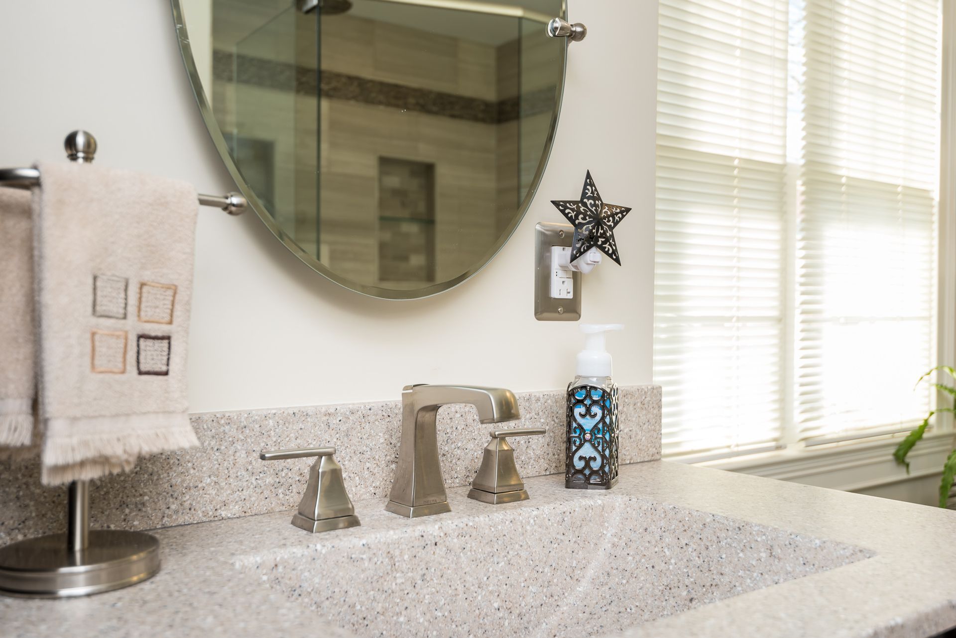A bathroom sink with a round mirror above it