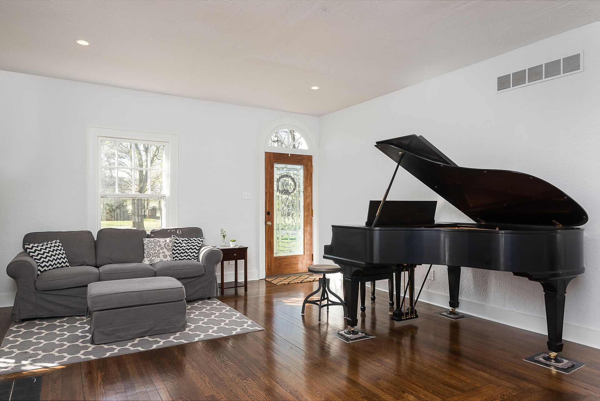 A living room with a piano and a couch