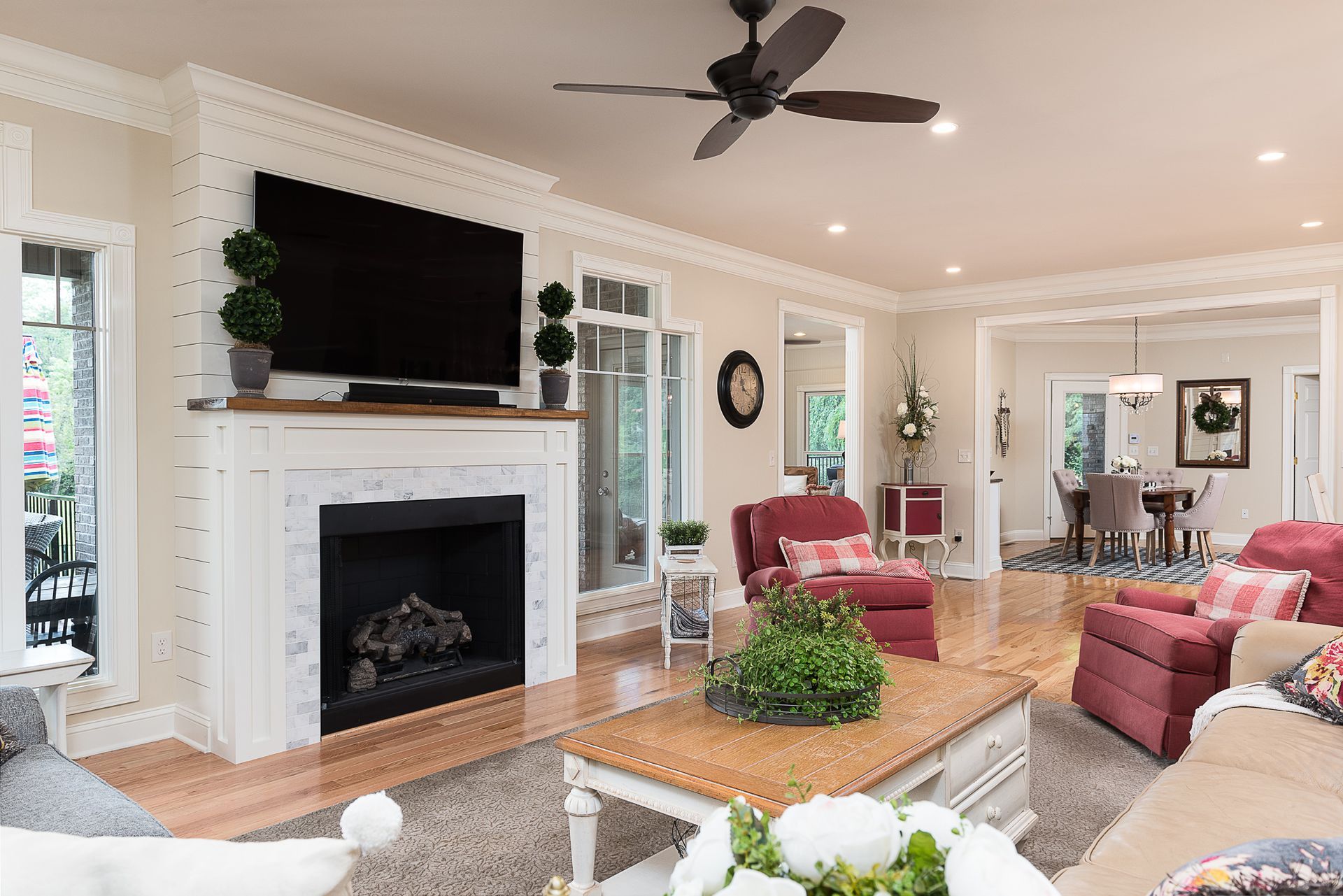A living room with a fireplace , television , and ceiling fan.