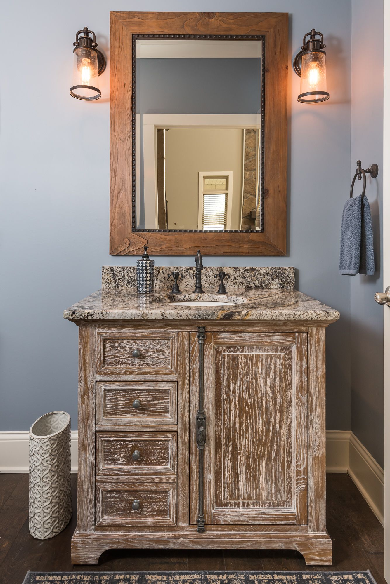 A bathroom with a sink , mirror , and towel rack.