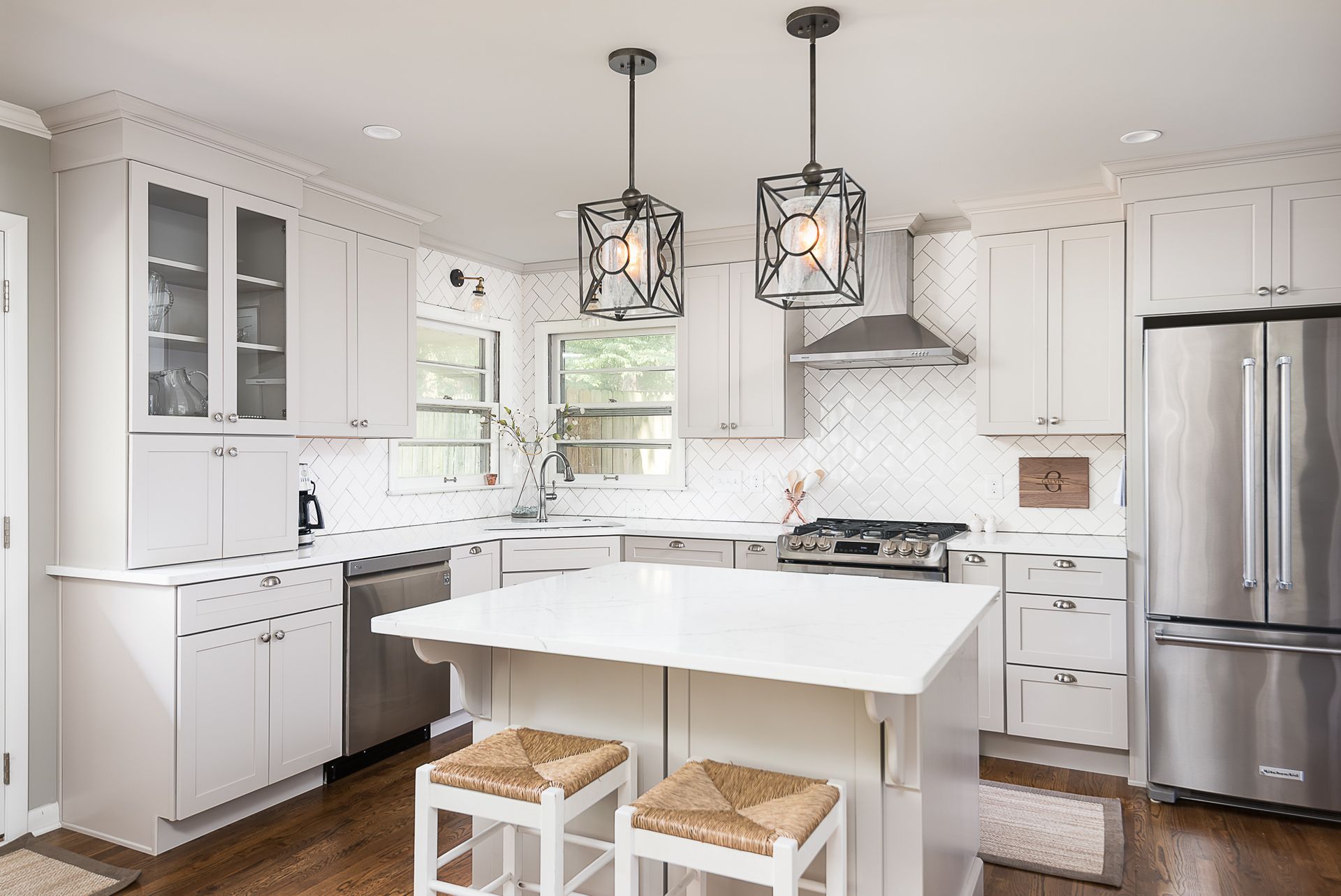 A kitchen with white cabinets , stainless steel appliances , and a large island.