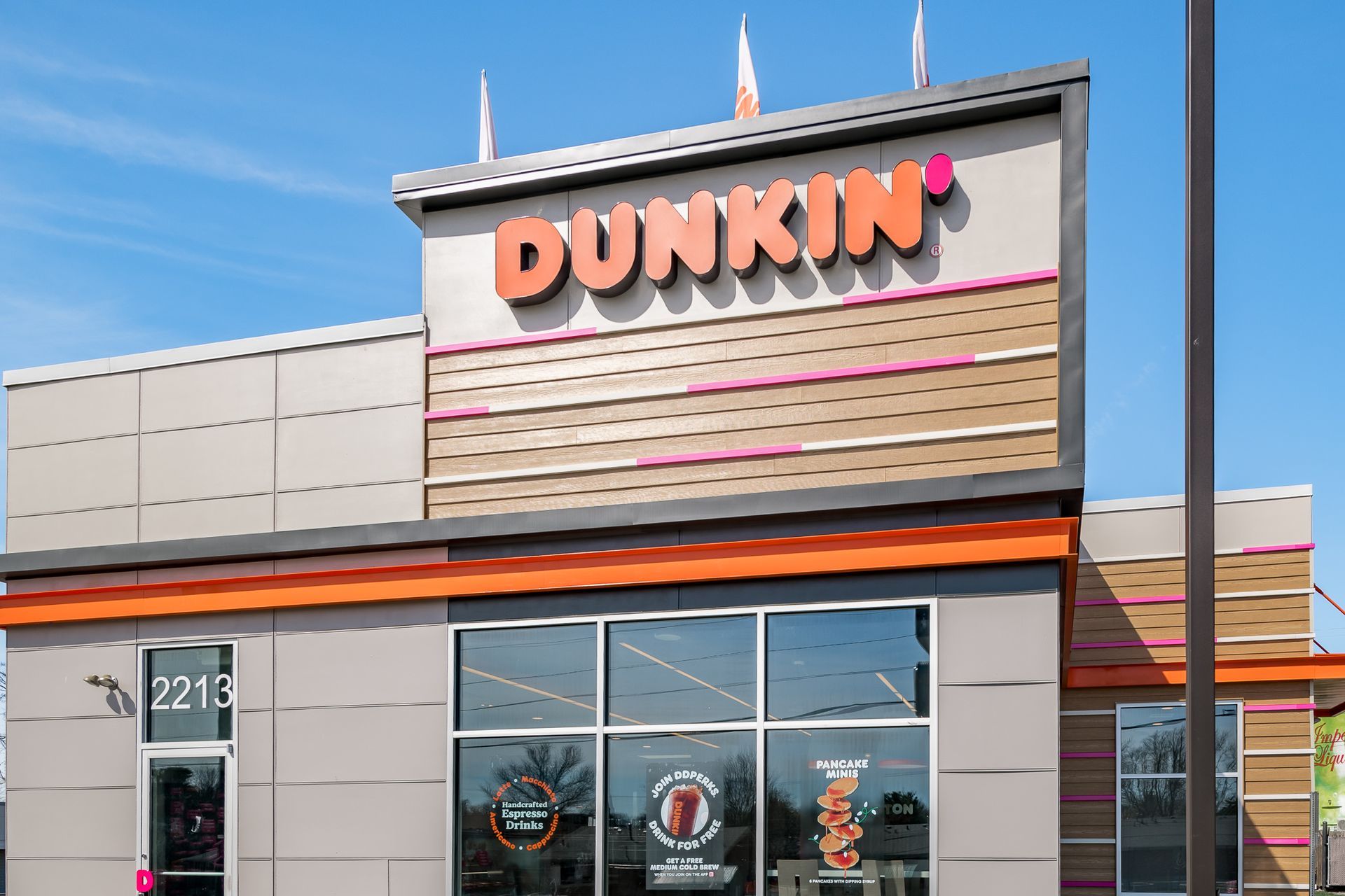 A dunkin ' donuts store with a blue sky in the background