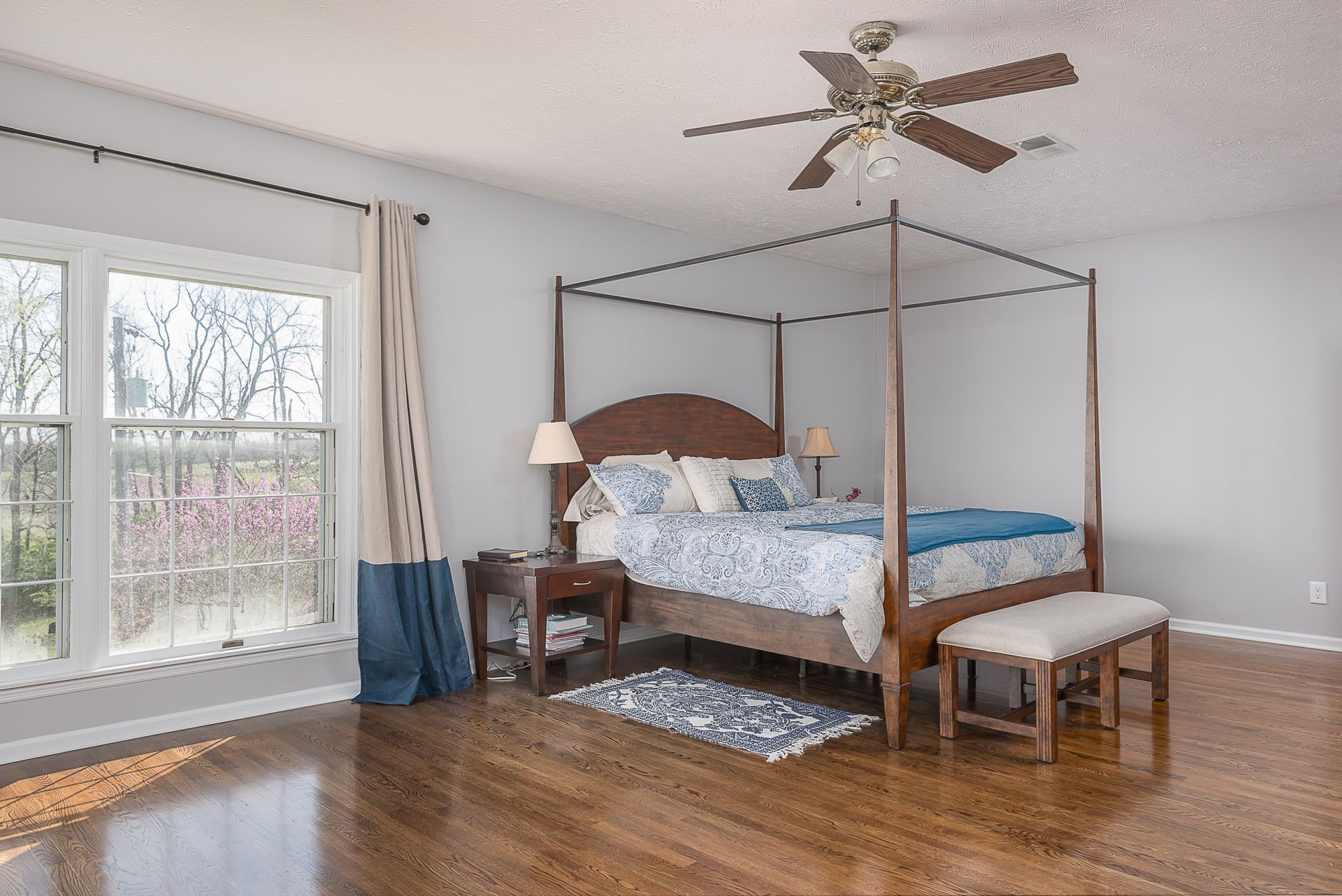 A bedroom with a canopy bed and a ceiling fan.