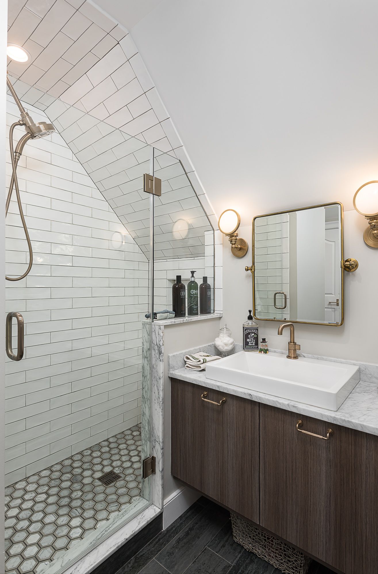 A bathroom with a walk in shower , sink and mirror.