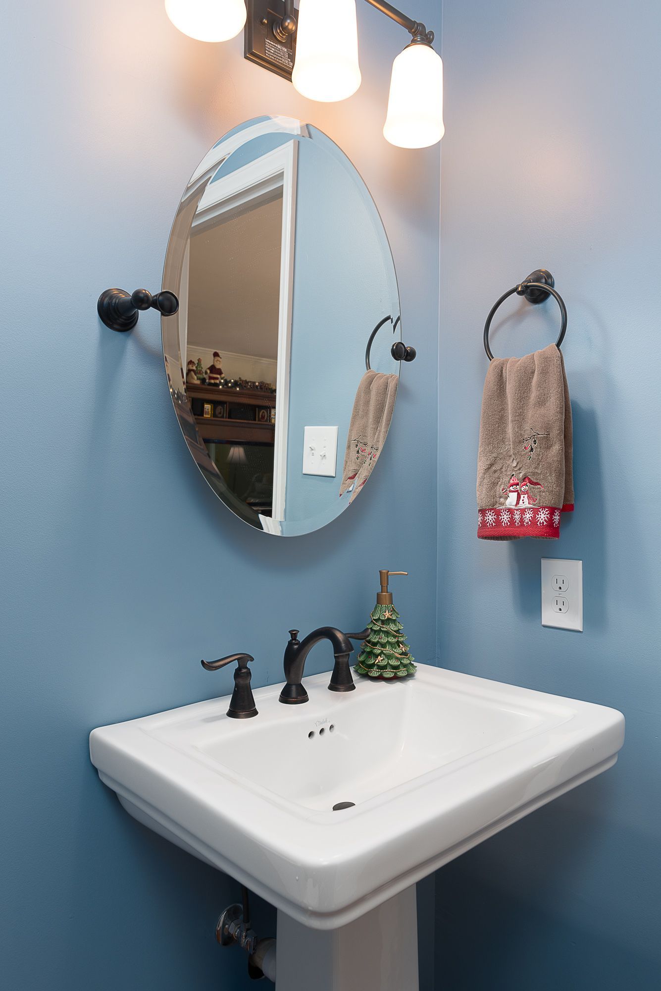 A bathroom sink with a mirror and a towel hanging on the wall.