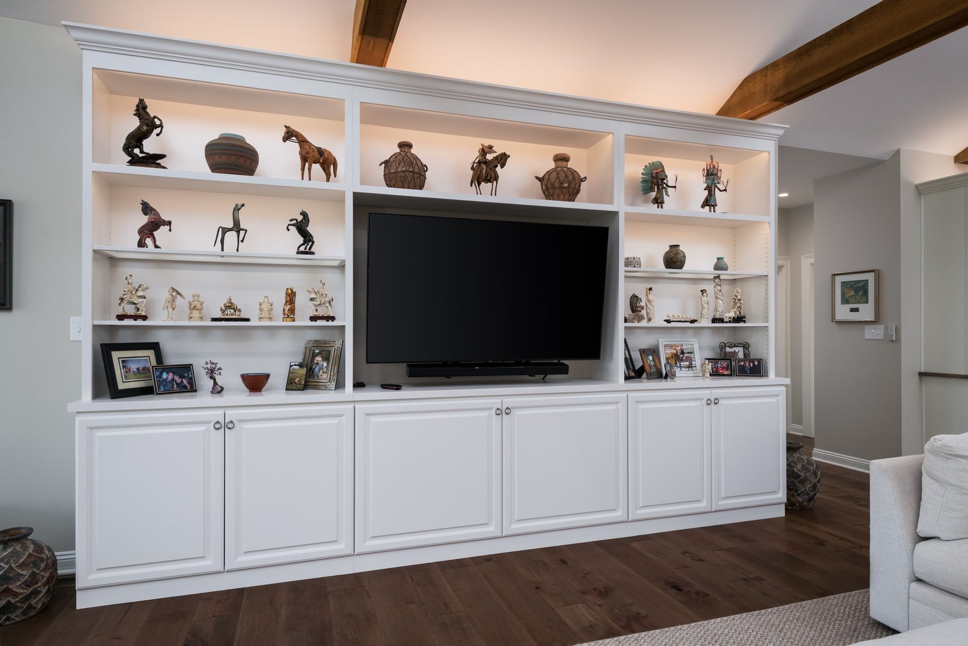 A living room with a large entertainment center and a flat screen tv.