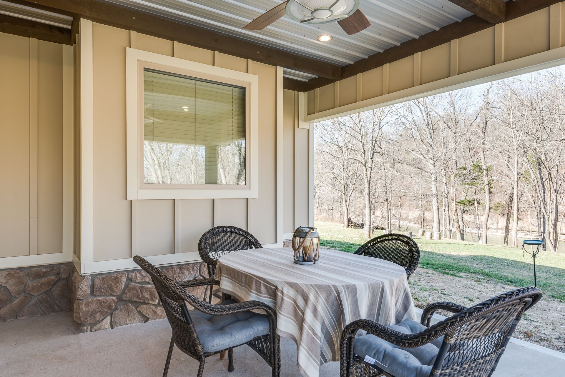 A patio with a table and chairs under a ceiling fan.