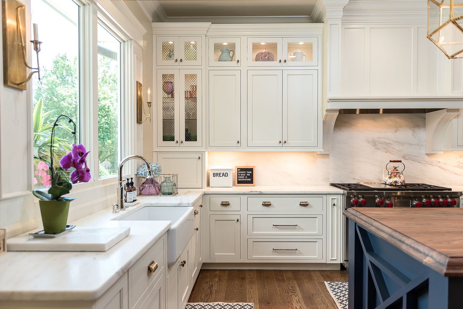 A kitchen with white cabinets , a sink , and a stove.