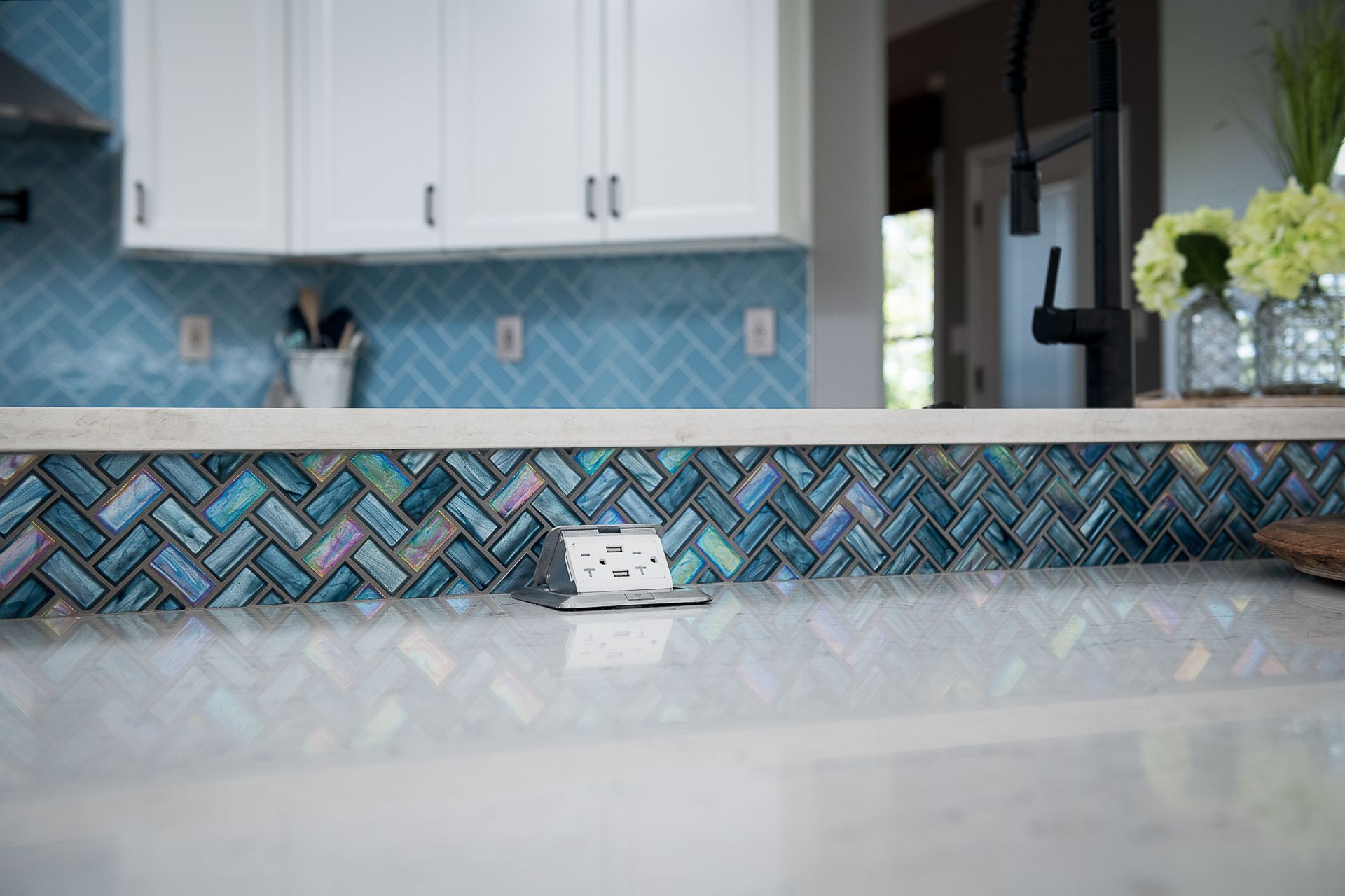 A kitchen with blue tiles and a white counter top.