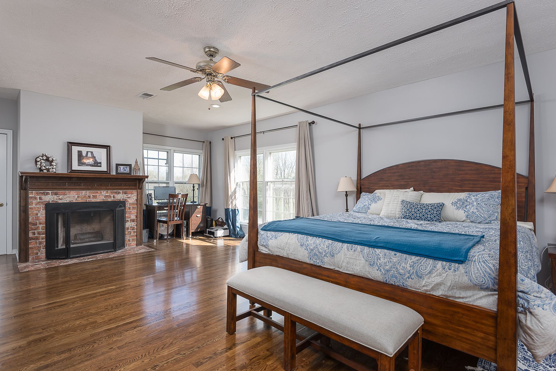 A bedroom with a four poster bed and a fireplace