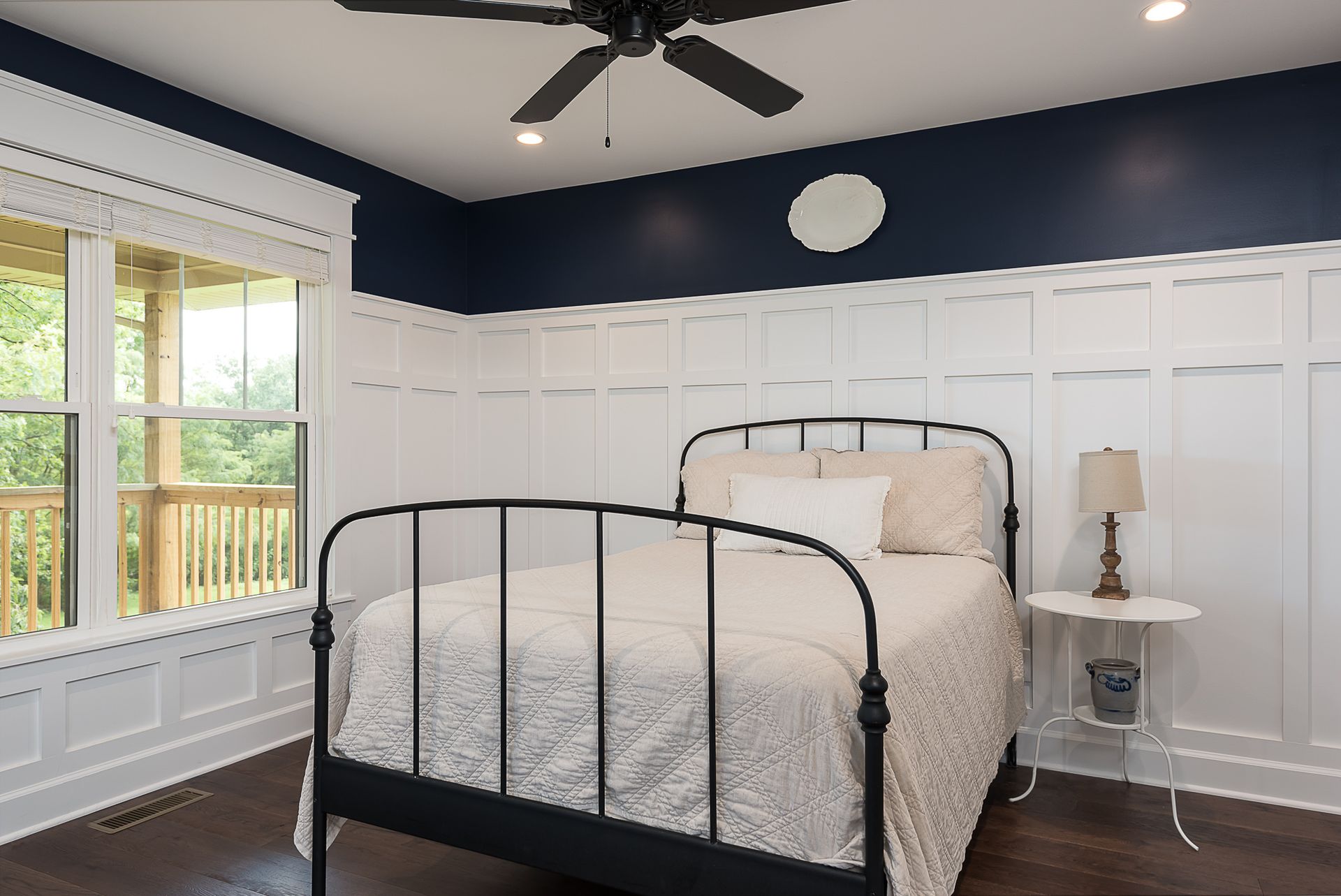 A bedroom with a bed and a ceiling fan.