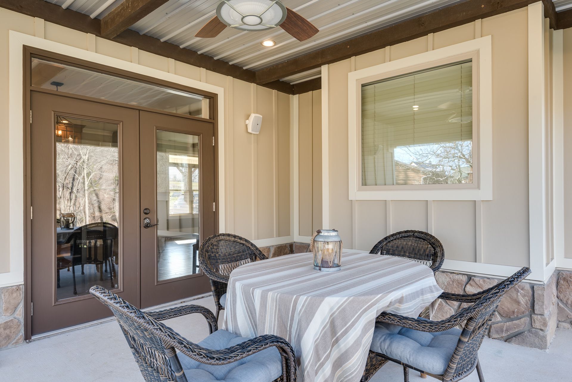 A patio with a table and chairs and a ceiling fan.