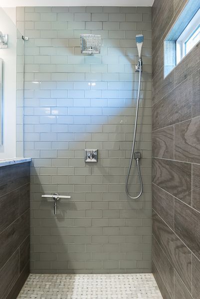 A bathroom with a walk in shower and a window.