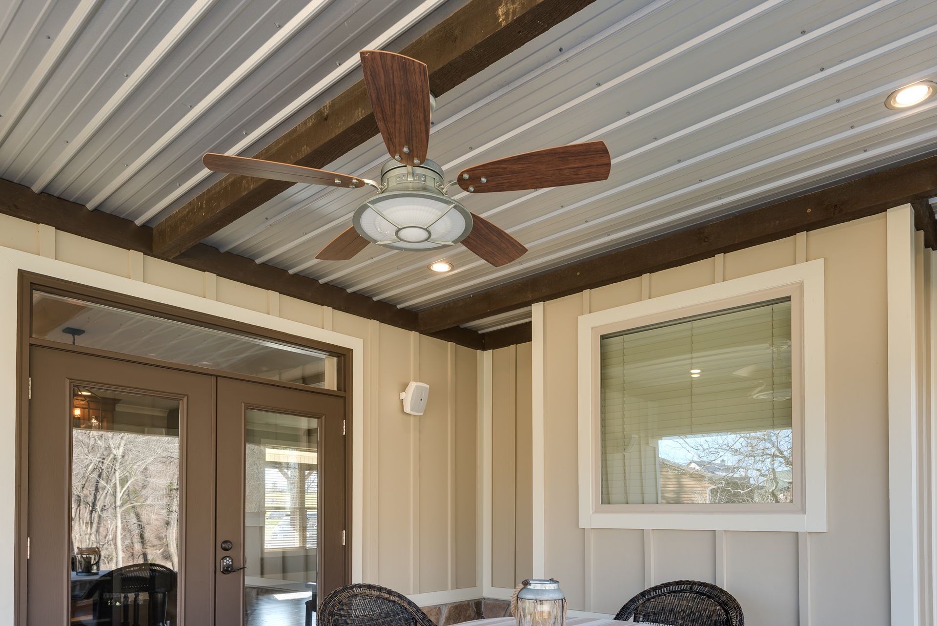 A patio with a table and chairs and a ceiling fan.
