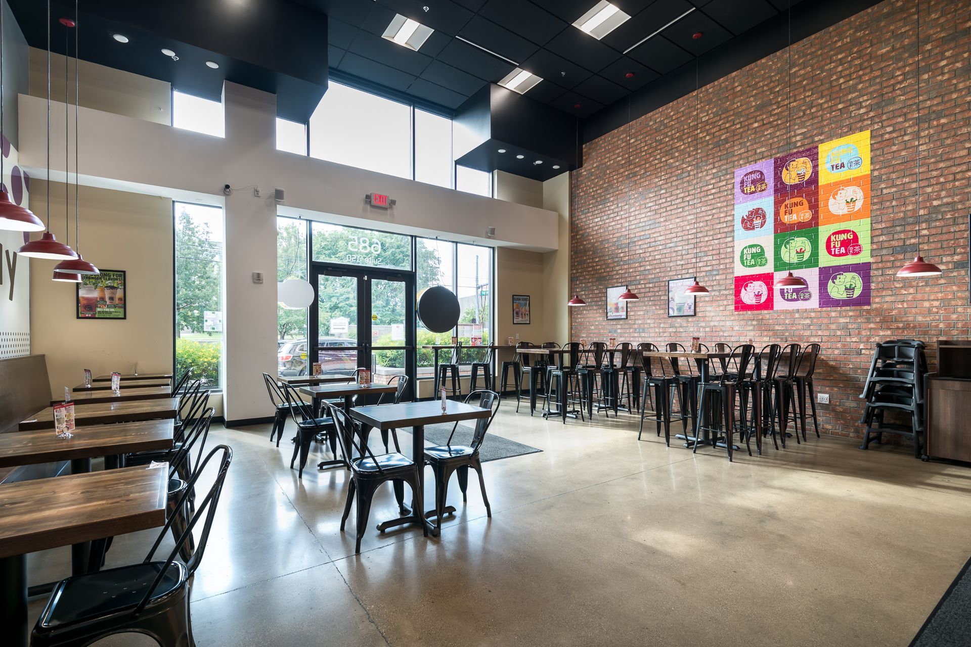 A restaurant with tables and chairs and a brick wall