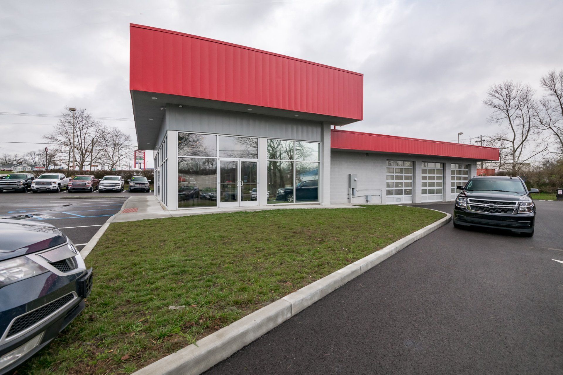 Cars are parked in front of a building with a red roof