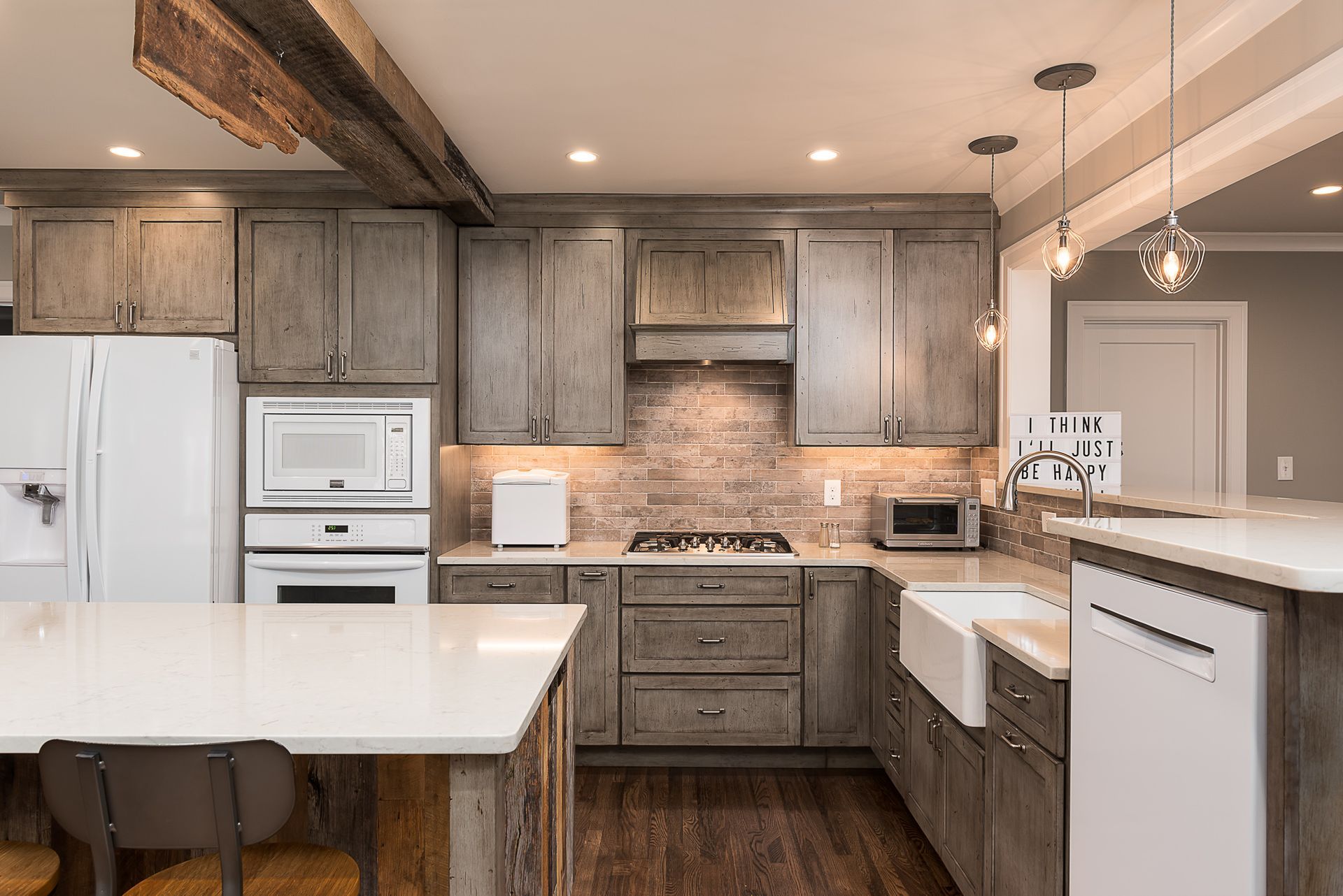 A kitchen with gray cabinets , white counter tops , a stove , a refrigerator , and a sink.