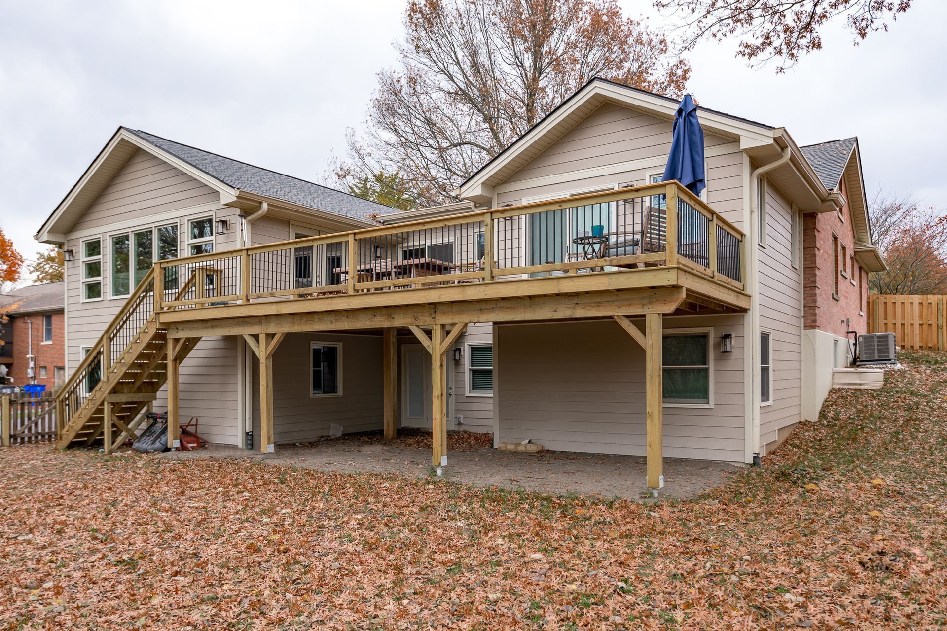 The back of a house with a large deck and stairs.