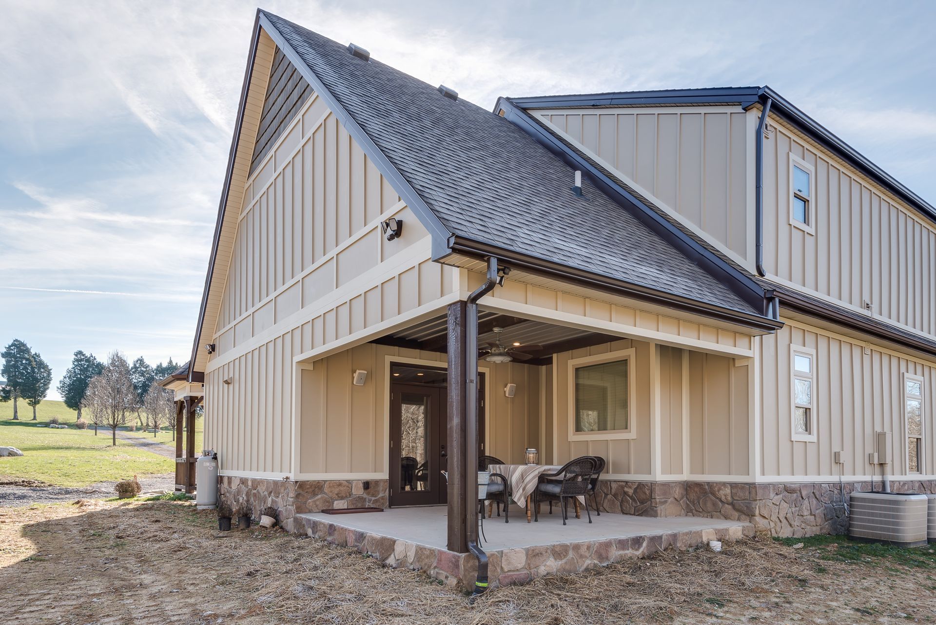 A large house with a porch and chairs on it.