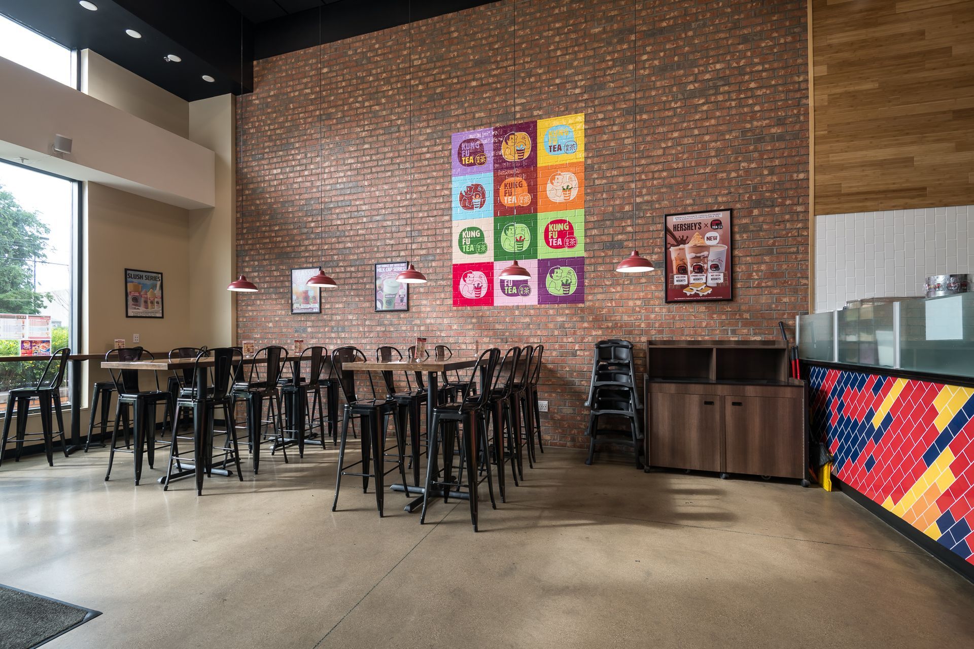 A restaurant with tables and chairs and a painting on the wall.