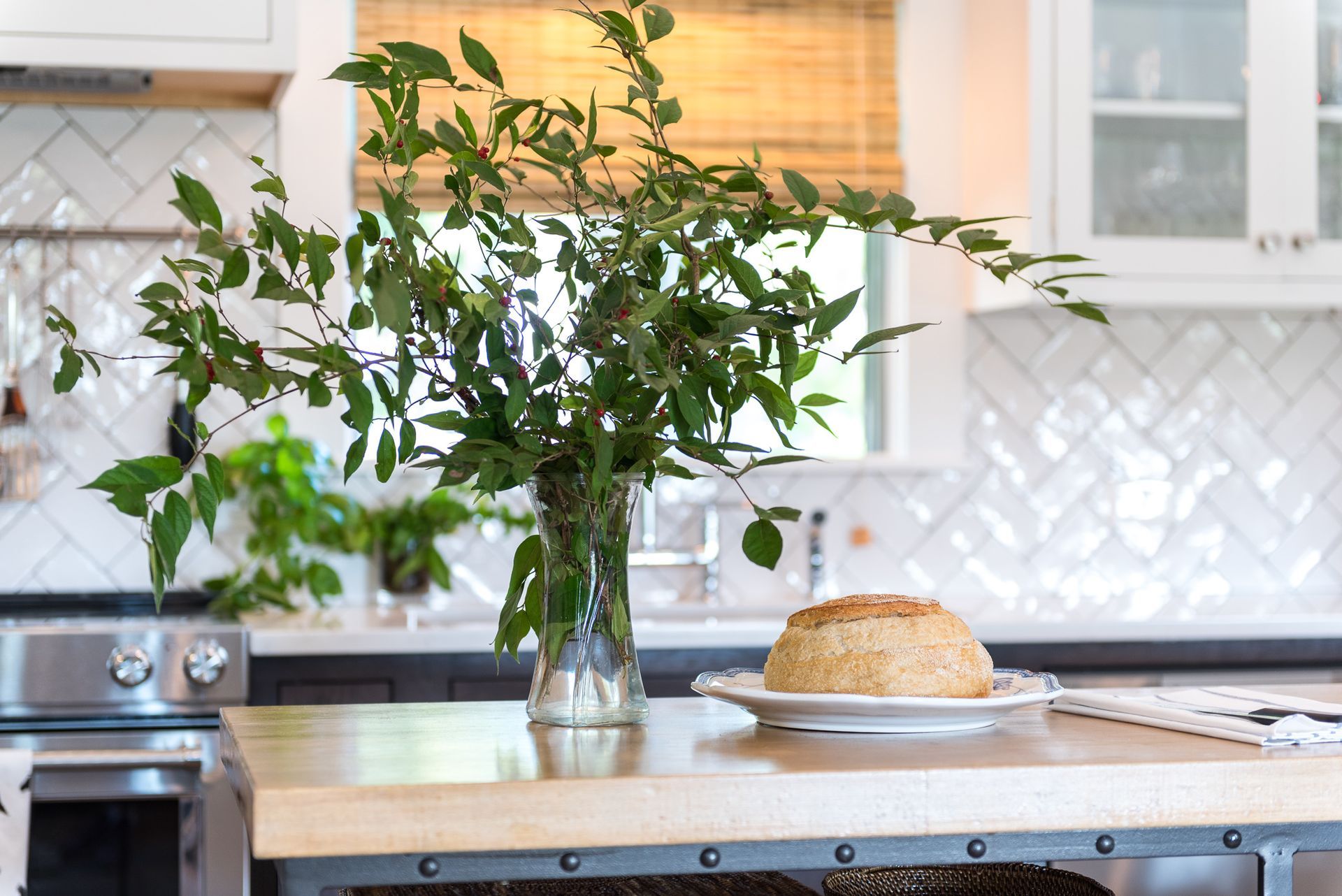 A kitchen island with a vase of flowers and a plate of food on it.
