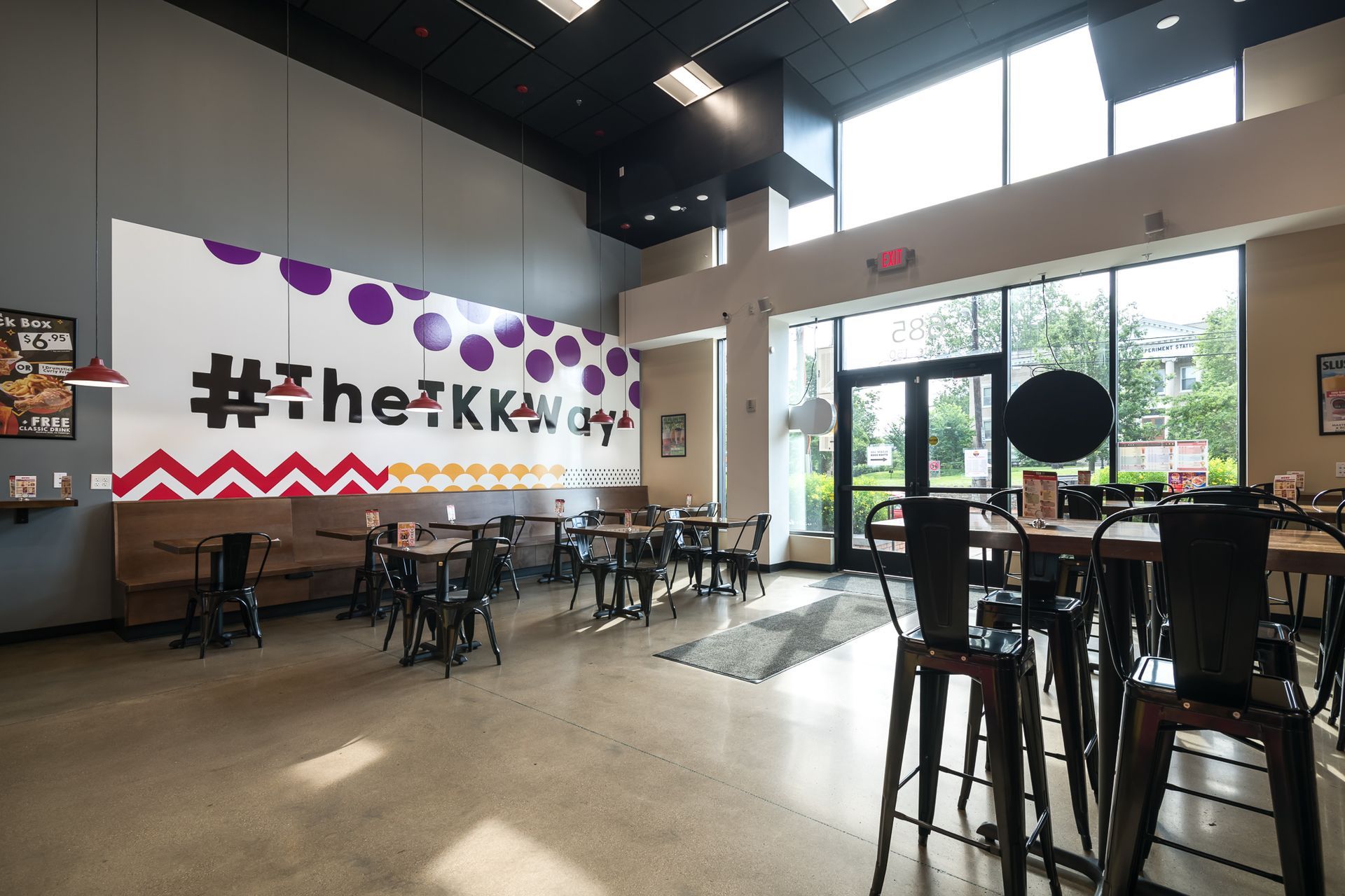 A restaurant with tables and chairs and a large sign on the wall.