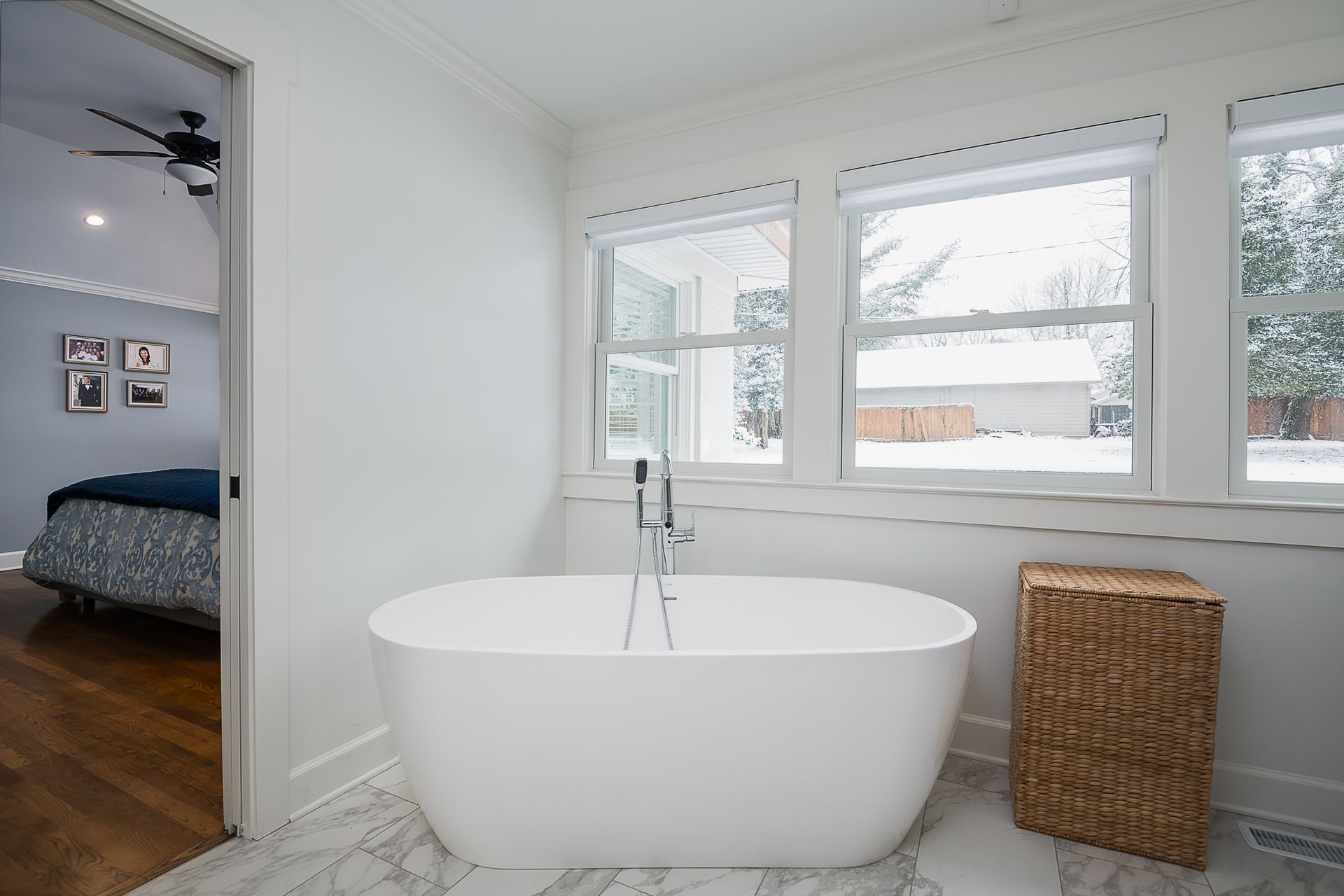 There is a bathtub in the middle of the bathroom next to a window.