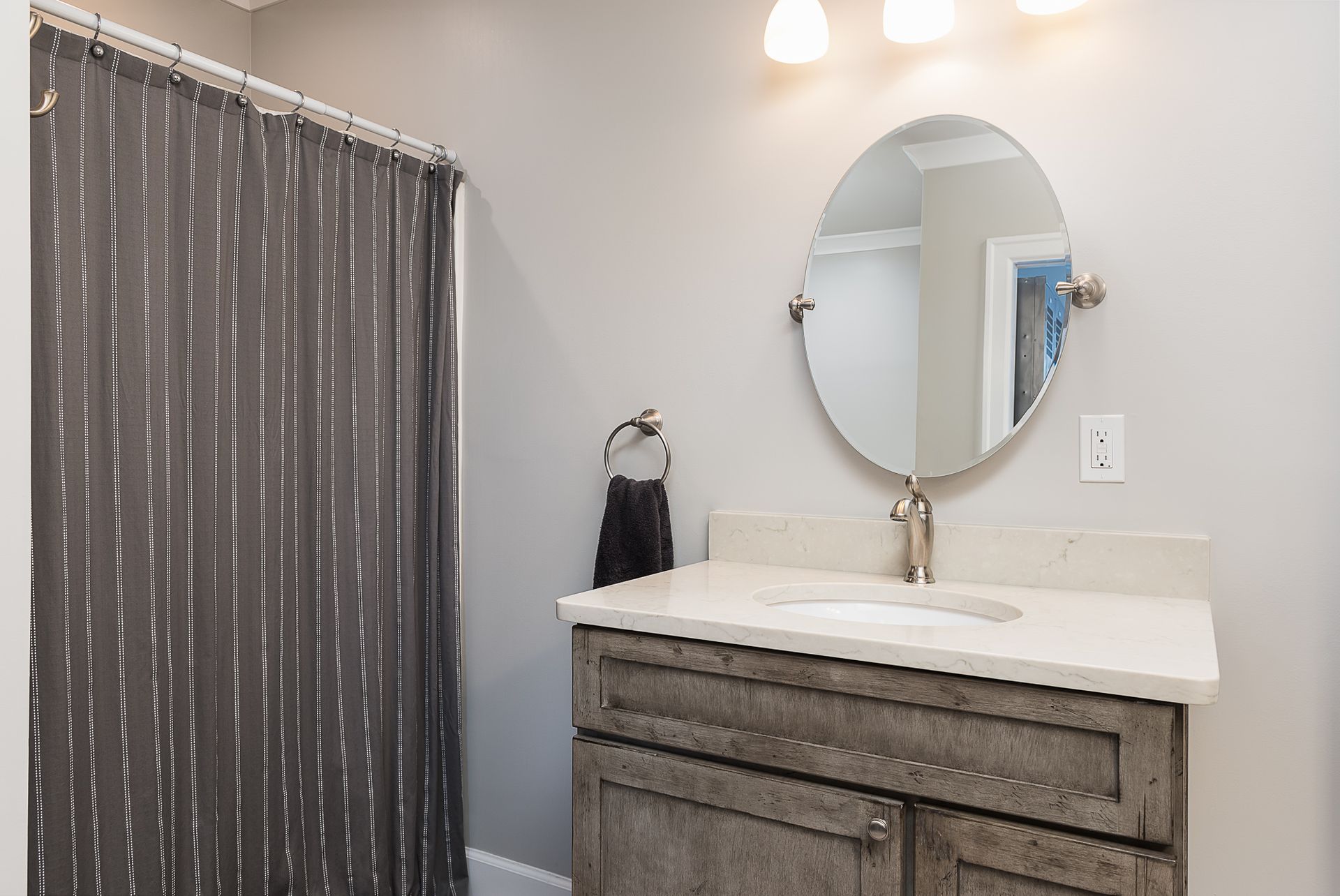 A bathroom with a sink , mirror and shower curtain.