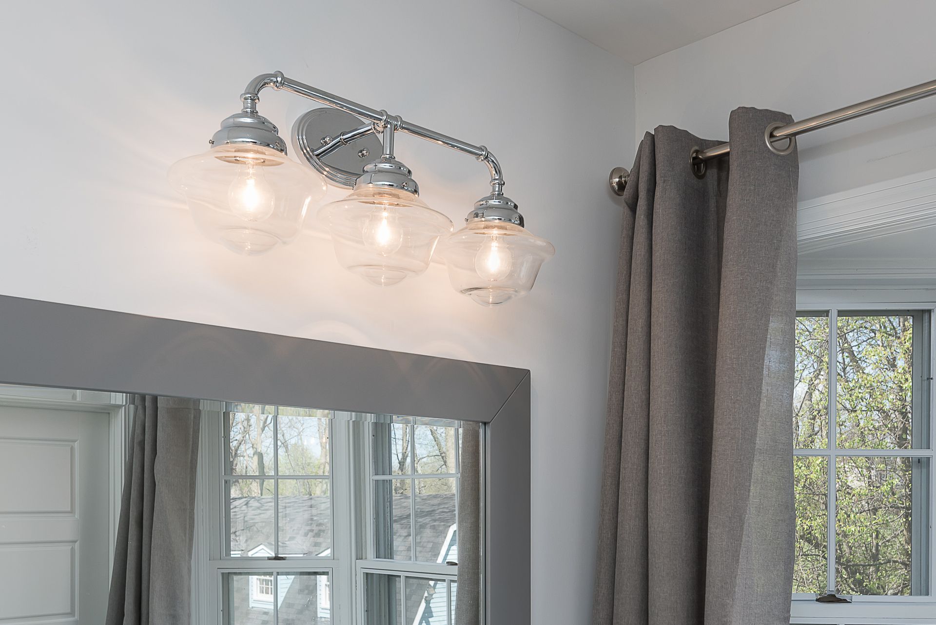 A bathroom with a vanity light and a mirror.
