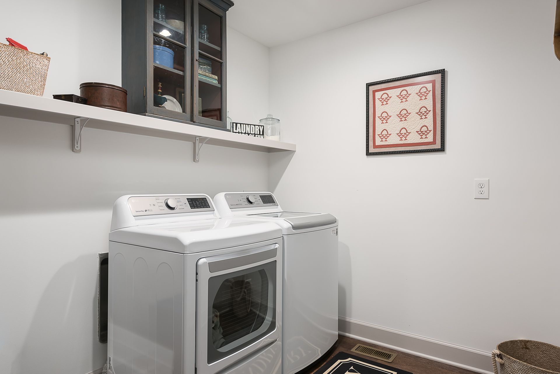 A laundry room with a washer and dryer and a picture on the wall.