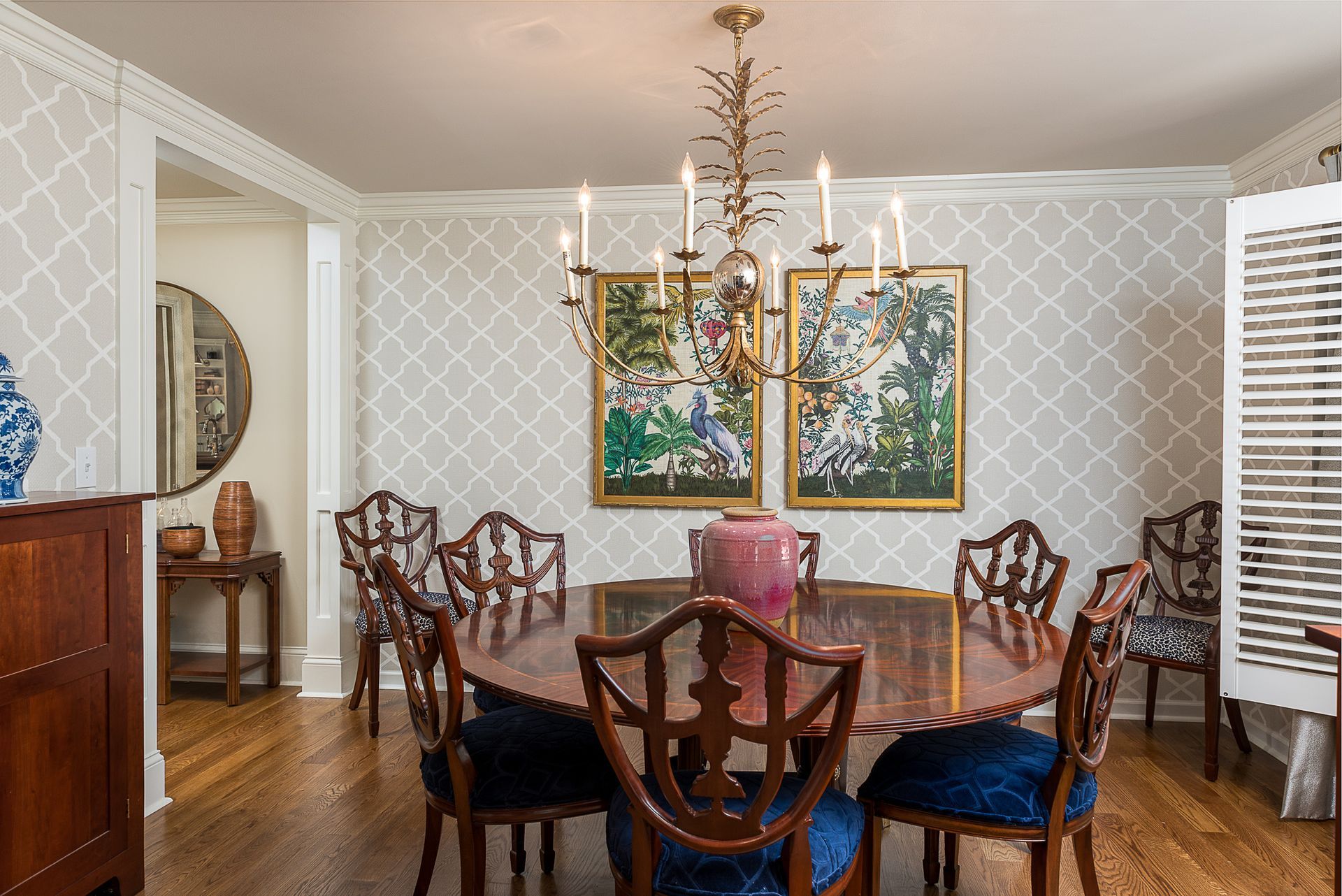 A dining room with a round table and chairs and a chandelier.
