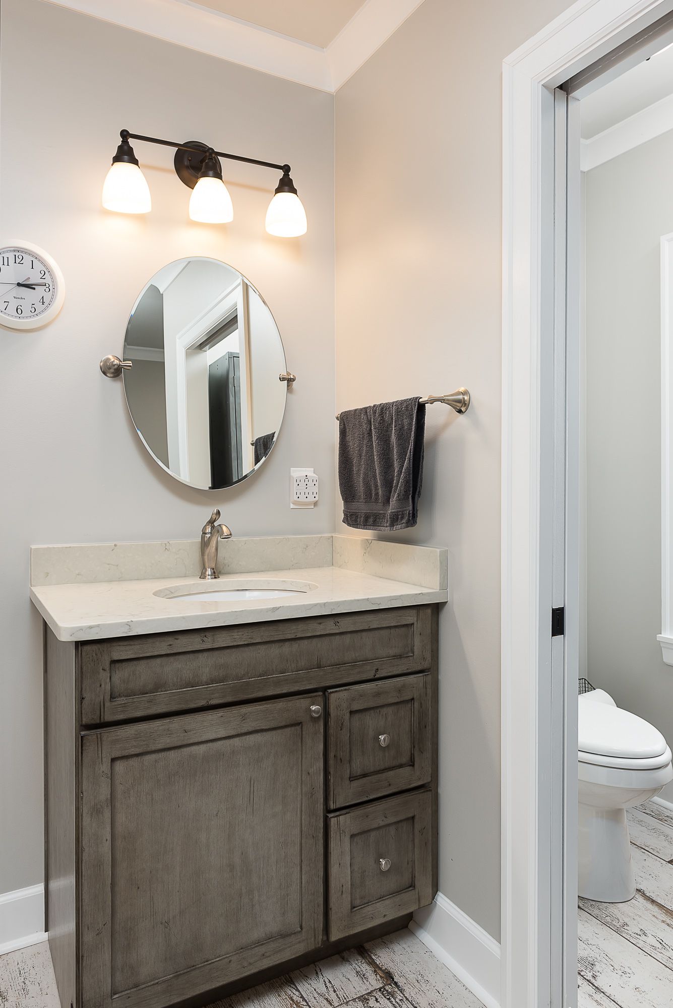 A bathroom with a sink , mirror and toilet.