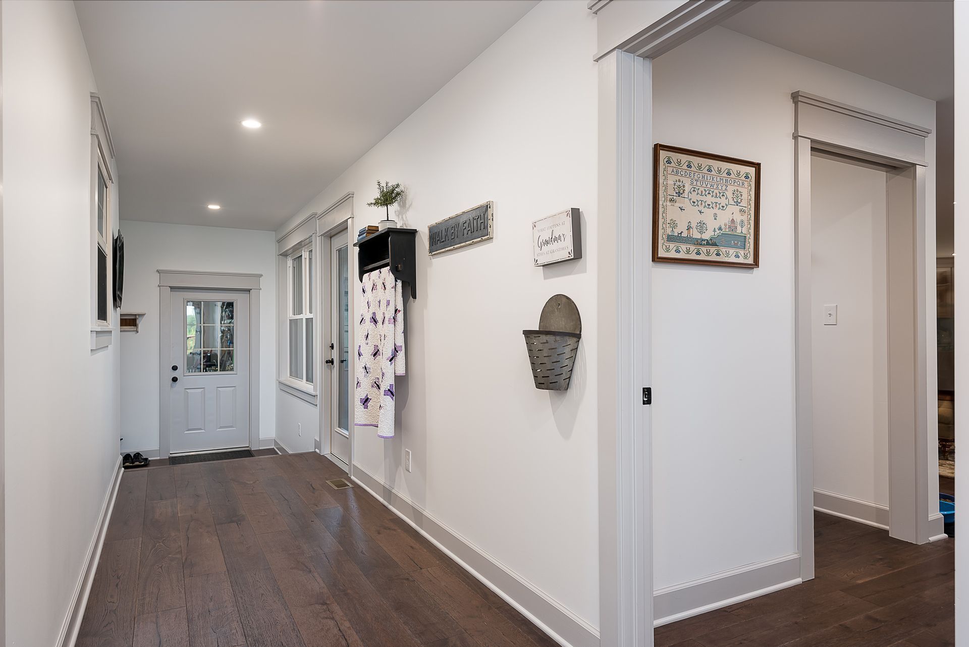 A long hallway with hardwood floors and white walls
