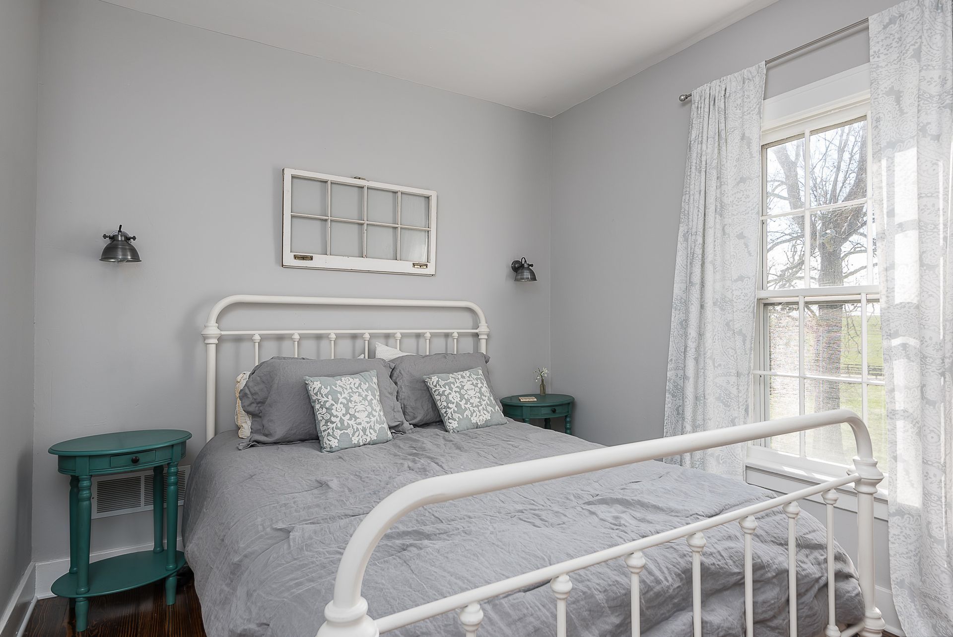 A bedroom with a bed , nightstand , and window.