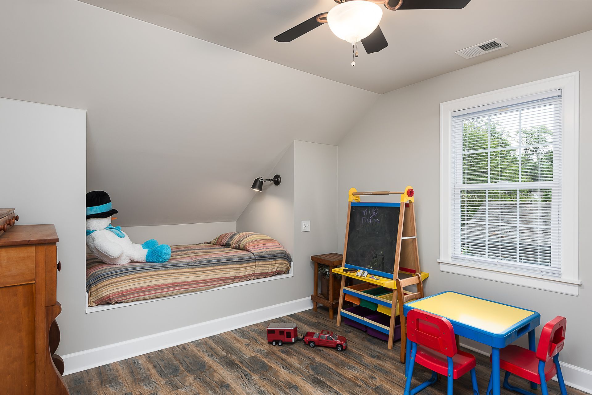A child 's room with a bed , table and chairs.