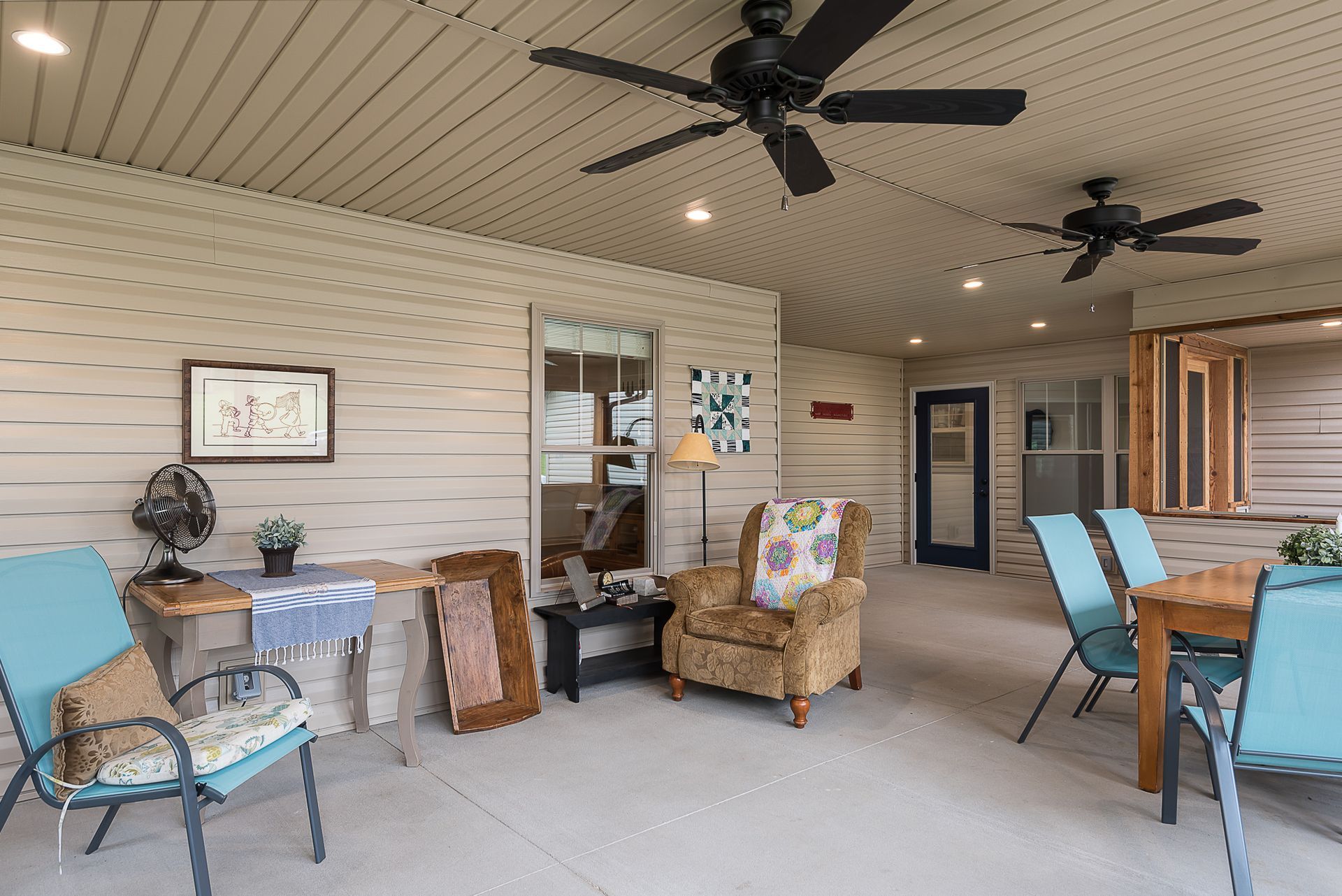 A living room with a table and chairs and a ceiling fan.