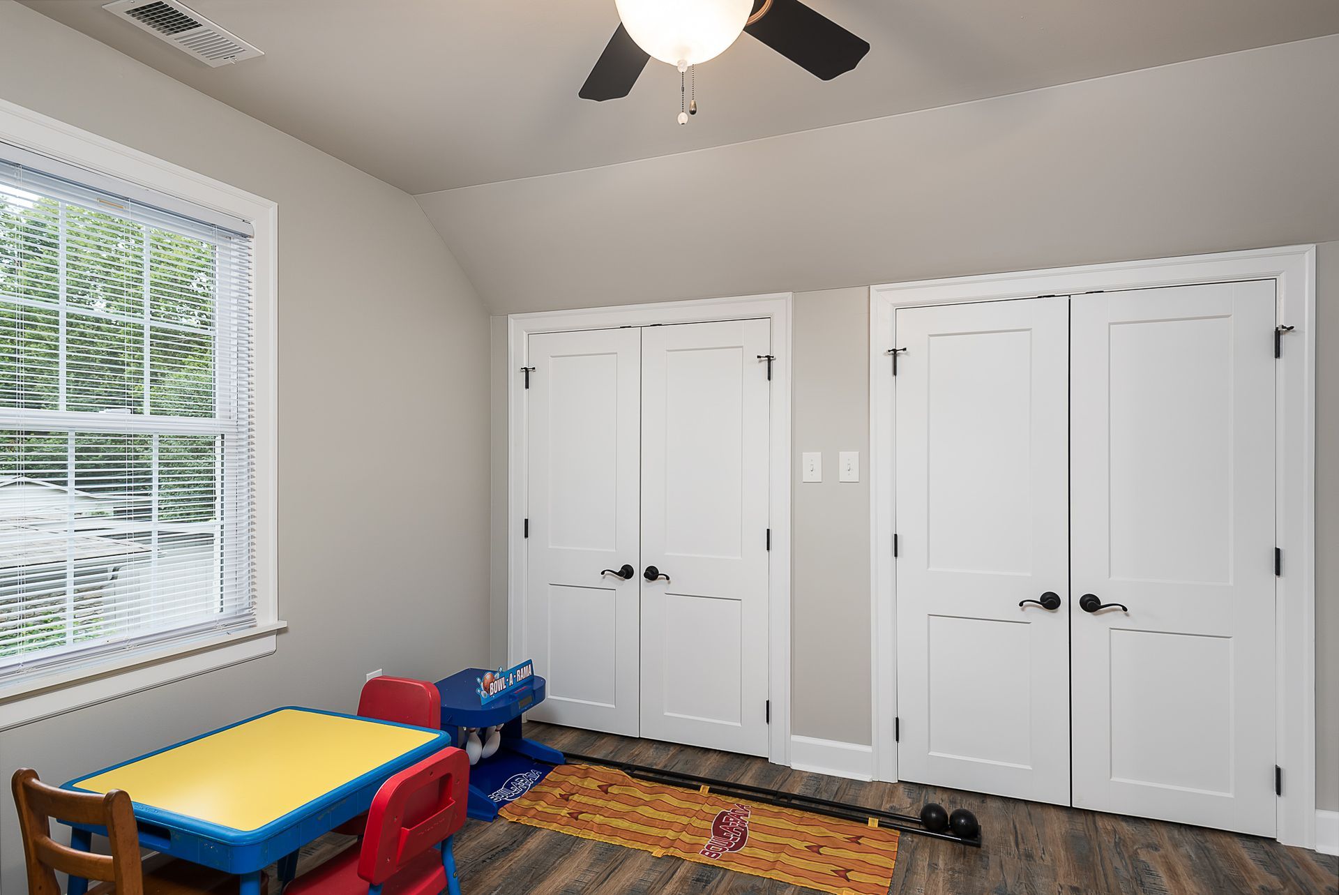 A room with a table and chairs and a ceiling fan.