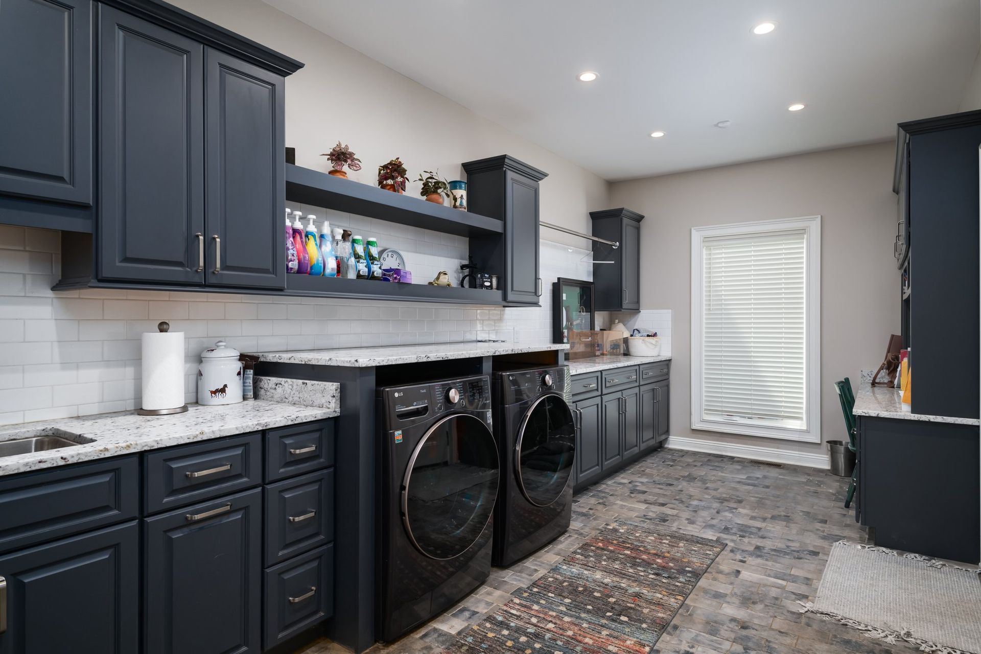 A laundry room with a washer and dryer and a sink.