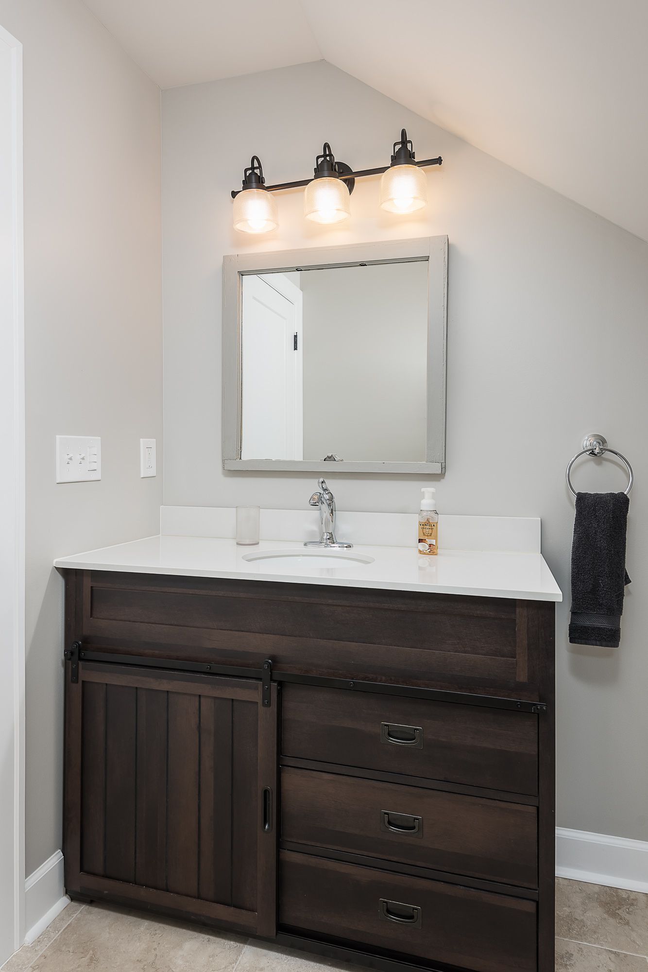 A bathroom with a sink , mirror and dresser.
