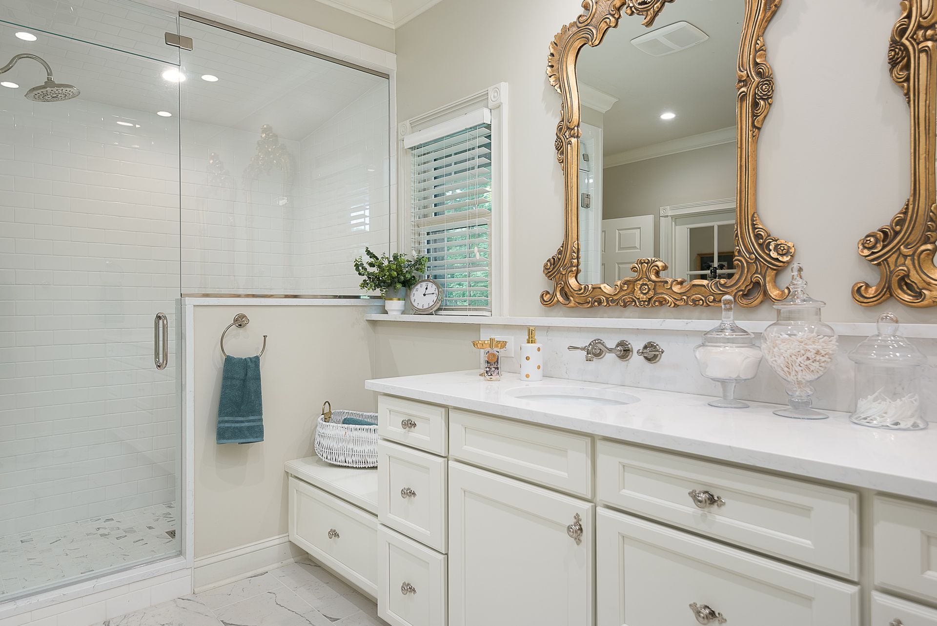A bathroom with two sinks , two mirrors and a walk in shower.